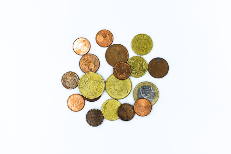 Gold coins scattered across a white surface, representing the diverse product options in a well-constructed precious metals portfolio