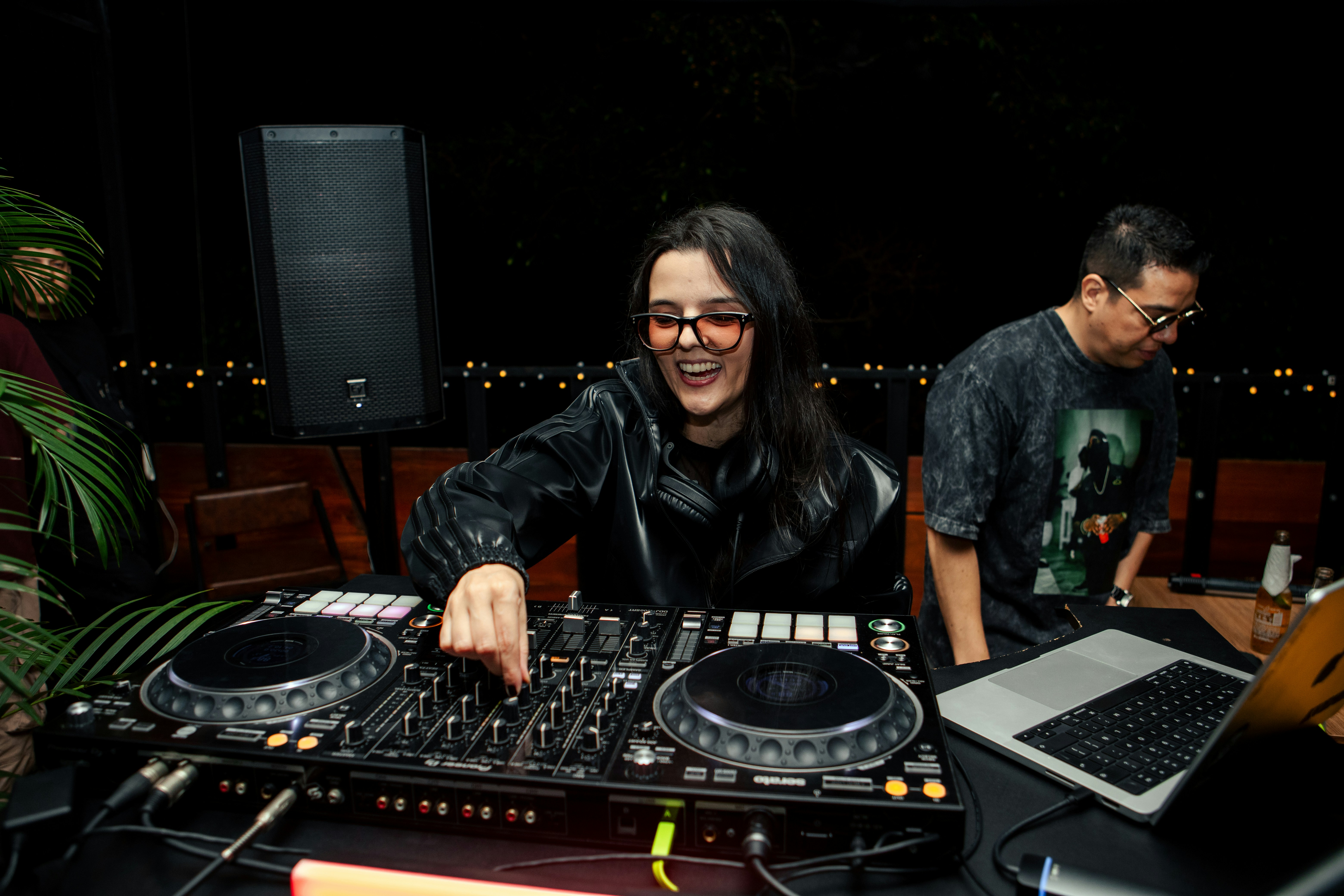 A woman smiling while djing at a party