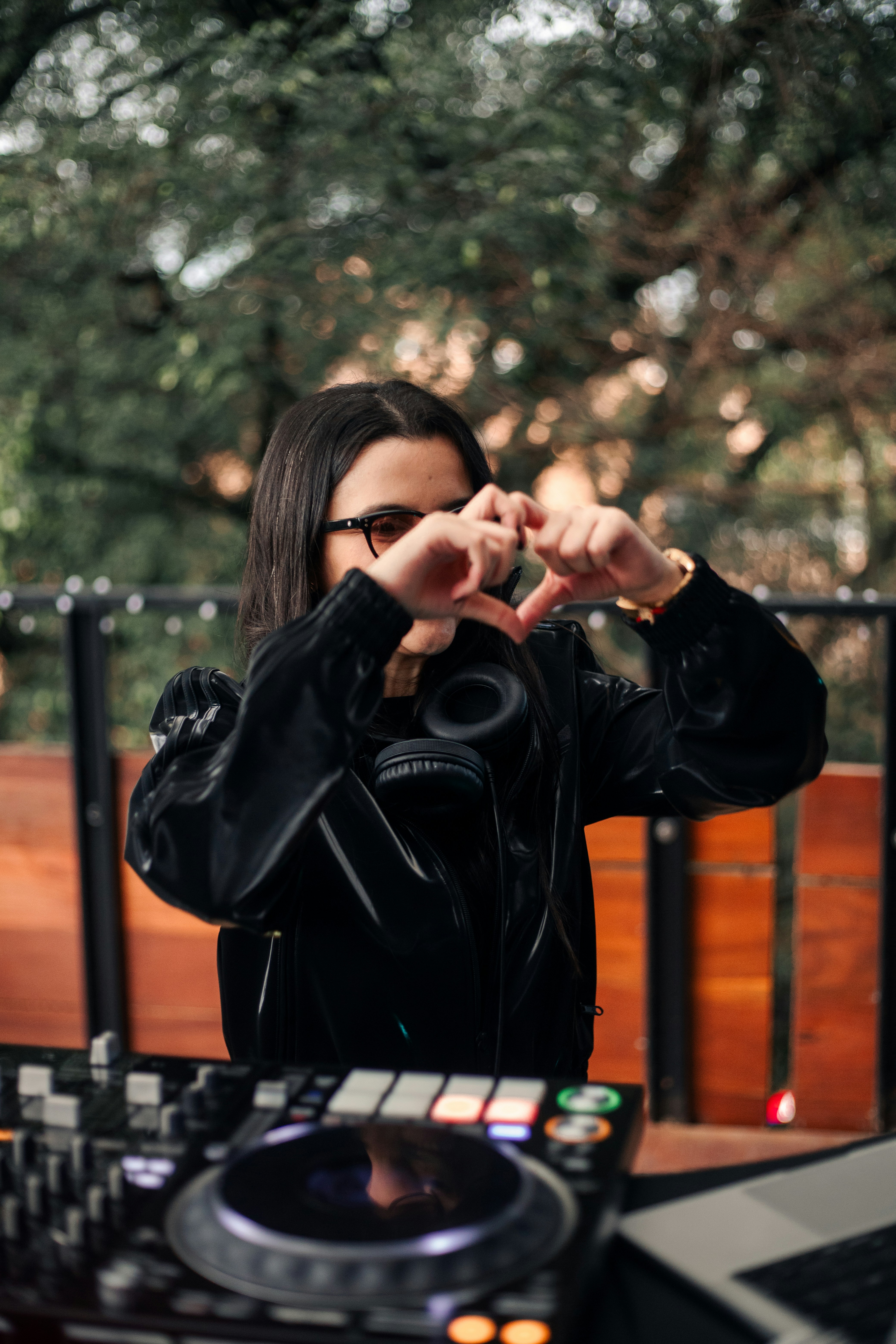 Dj making a heart shape with hands over equipment