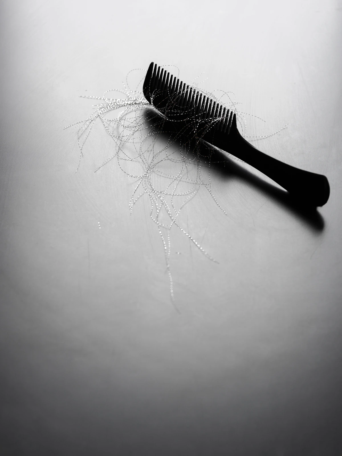 Comb with loose hair strands, representing hair loss consultation
