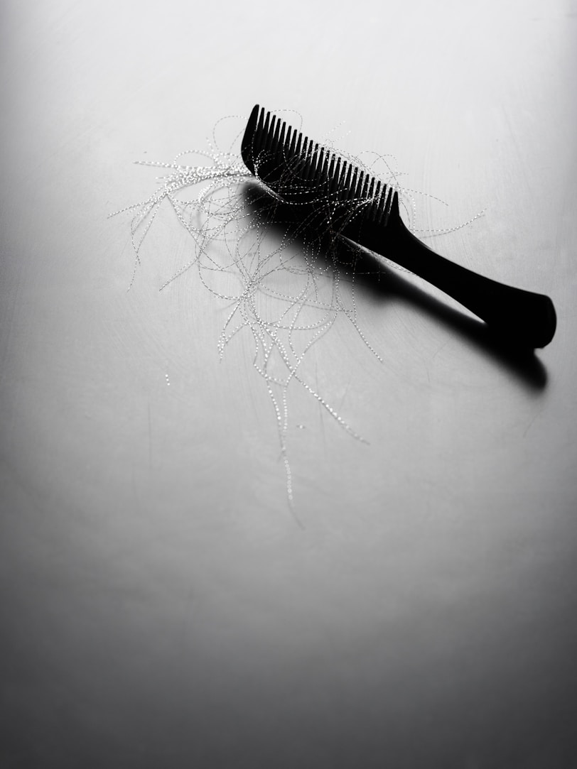 A black comb with loose strands of hair.