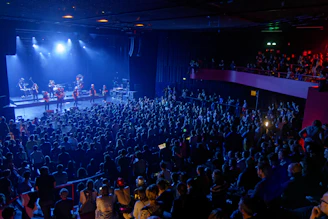 A band performs on stage for a large audience.