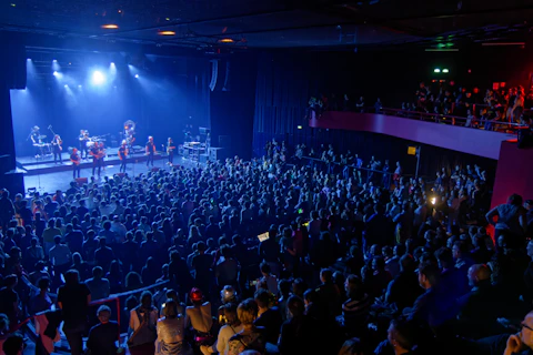 A band performs on stage for a large audience.