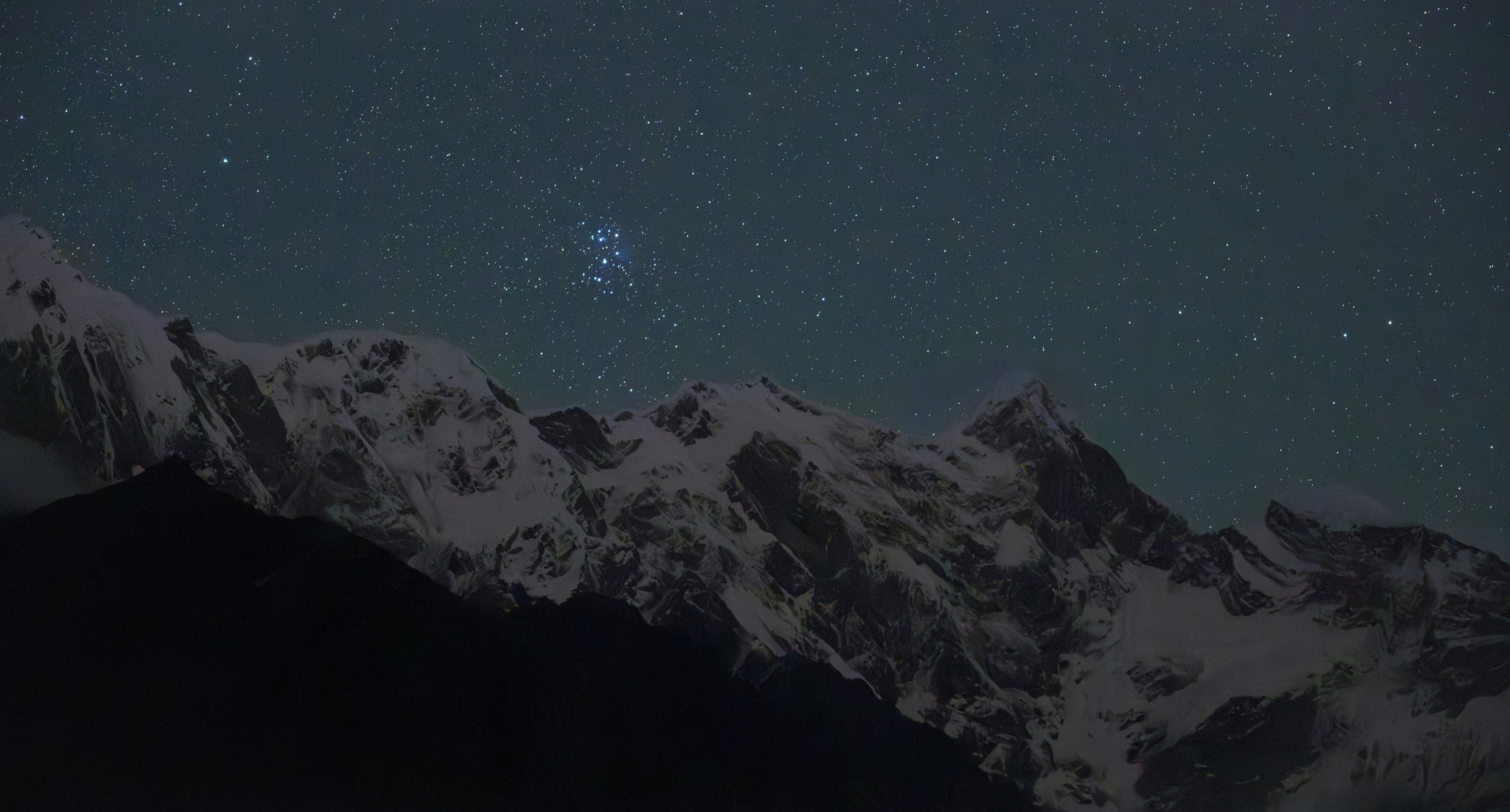 Snow-capped mountains under a starry night sky.