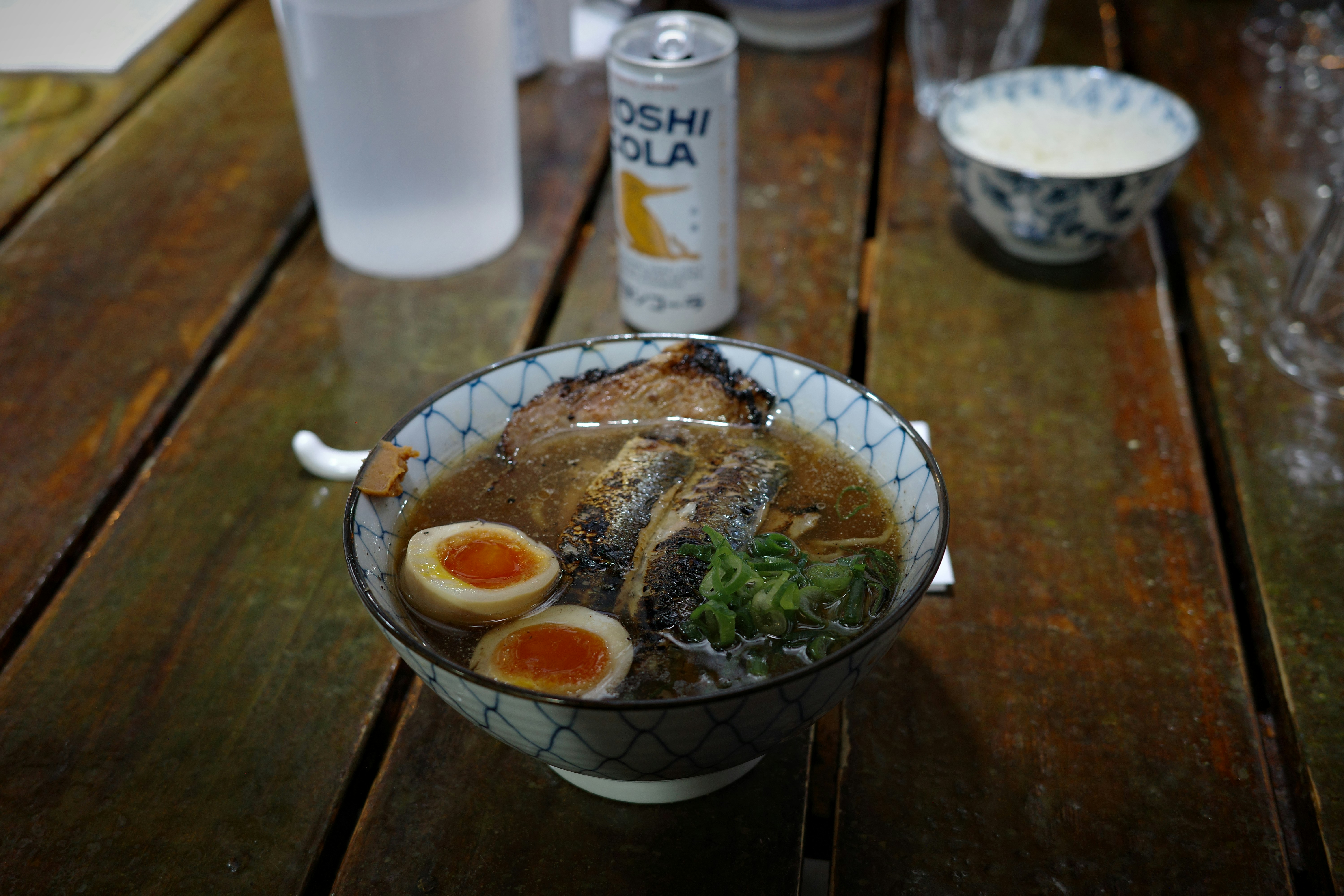 Tigela de ramen com ovo e carne sobre uma mesa de madeira