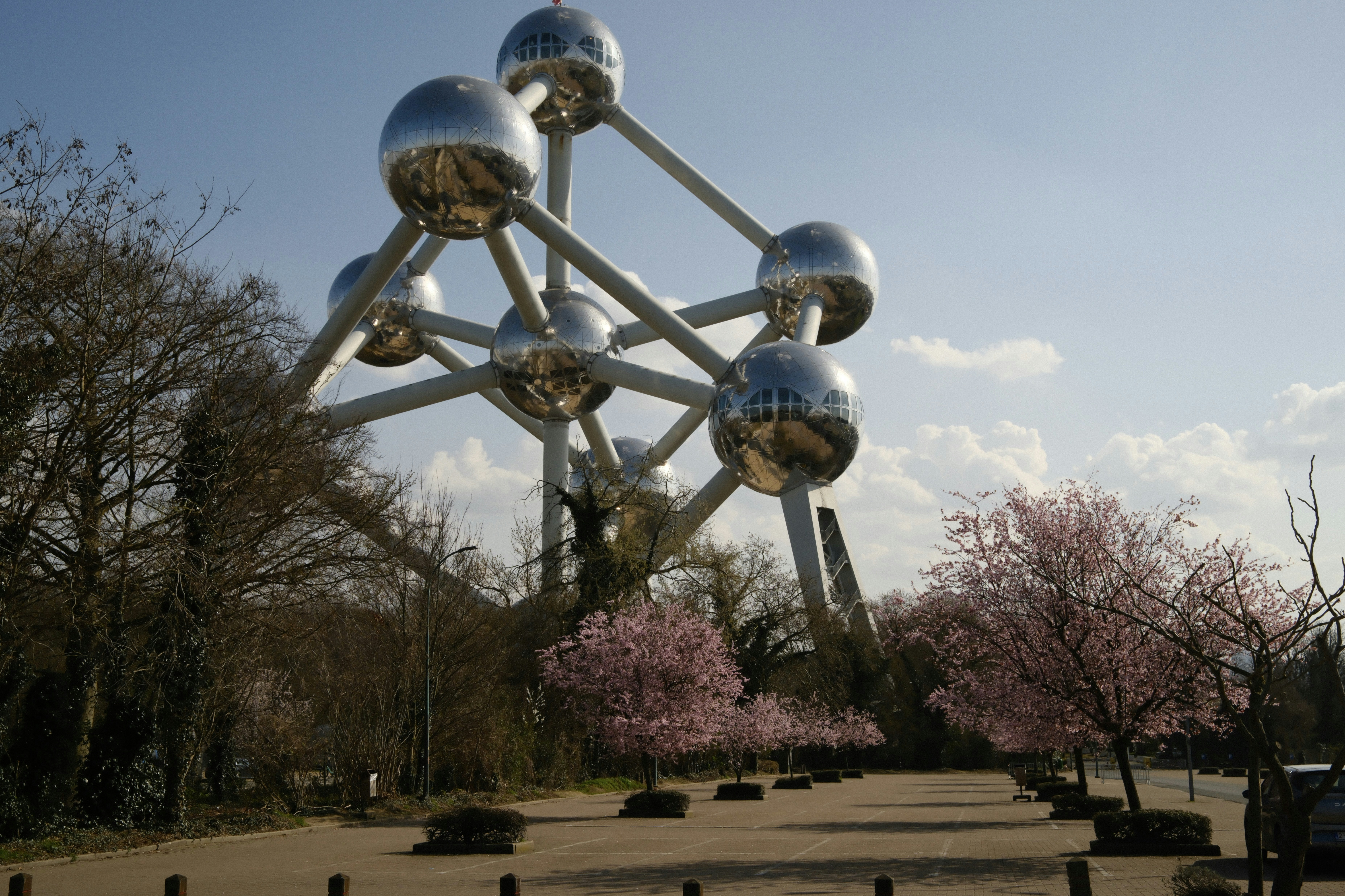Atomium structure with blooming cherry trees in park
