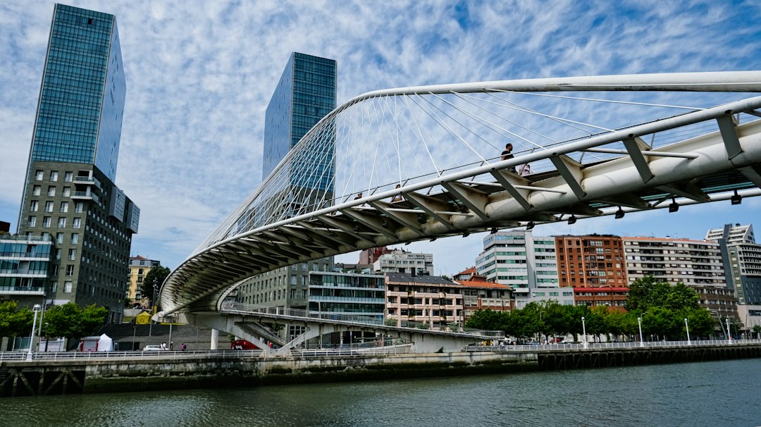 Calatrava's white curved Zubizuri footbridge over the Nervión with the Isozaki Atea towers behind