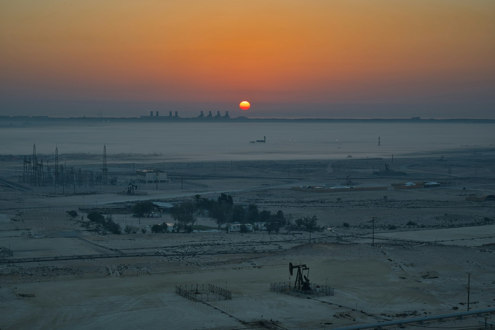 Pumpjack in an oil field at sunrise