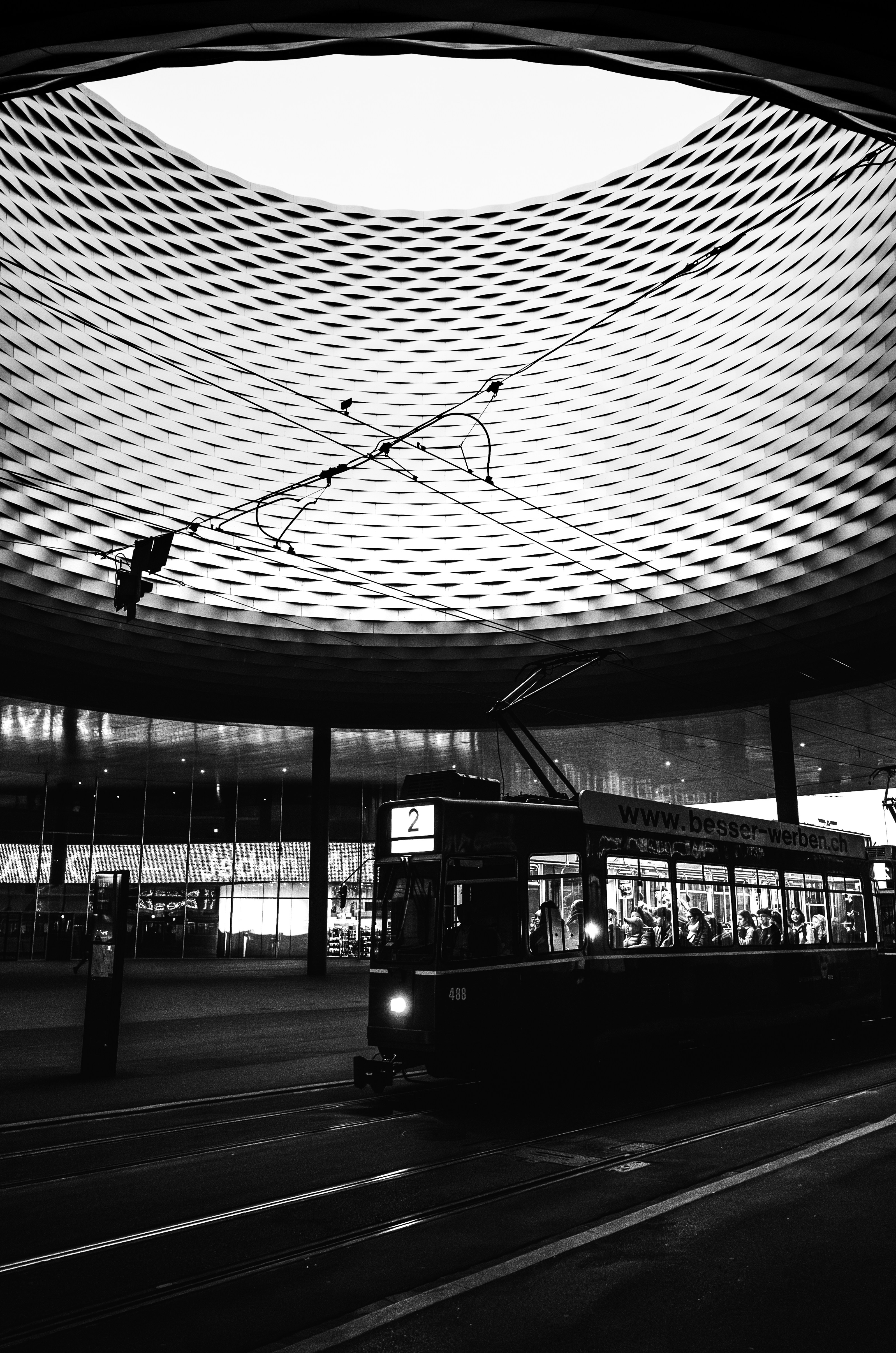 Un tramway attend sous un plafond moderne à motifs.