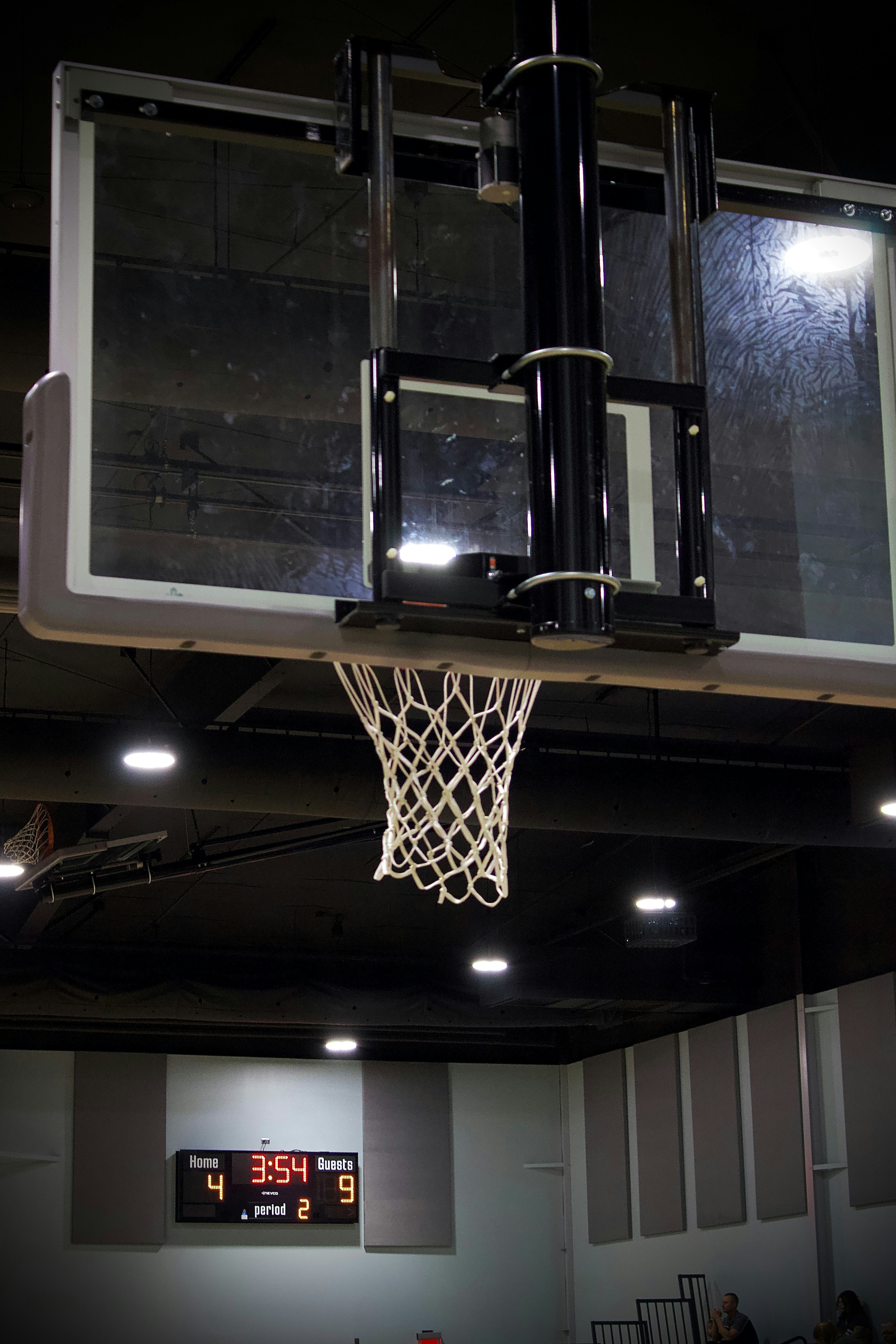 Basketball hoop and scoreboard in gymnasium