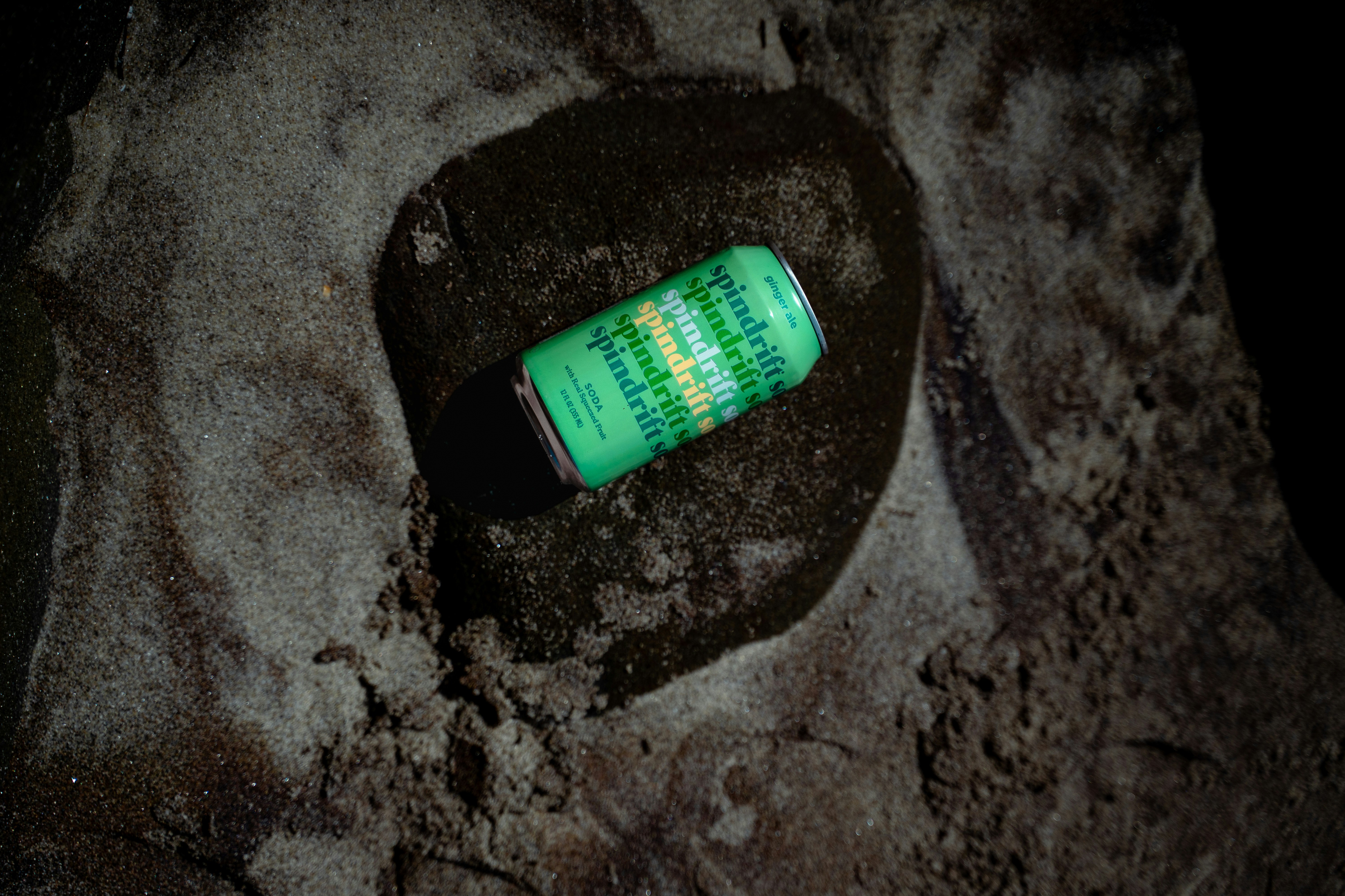 Una lata de rayas verdes y amarillas sobre la arena