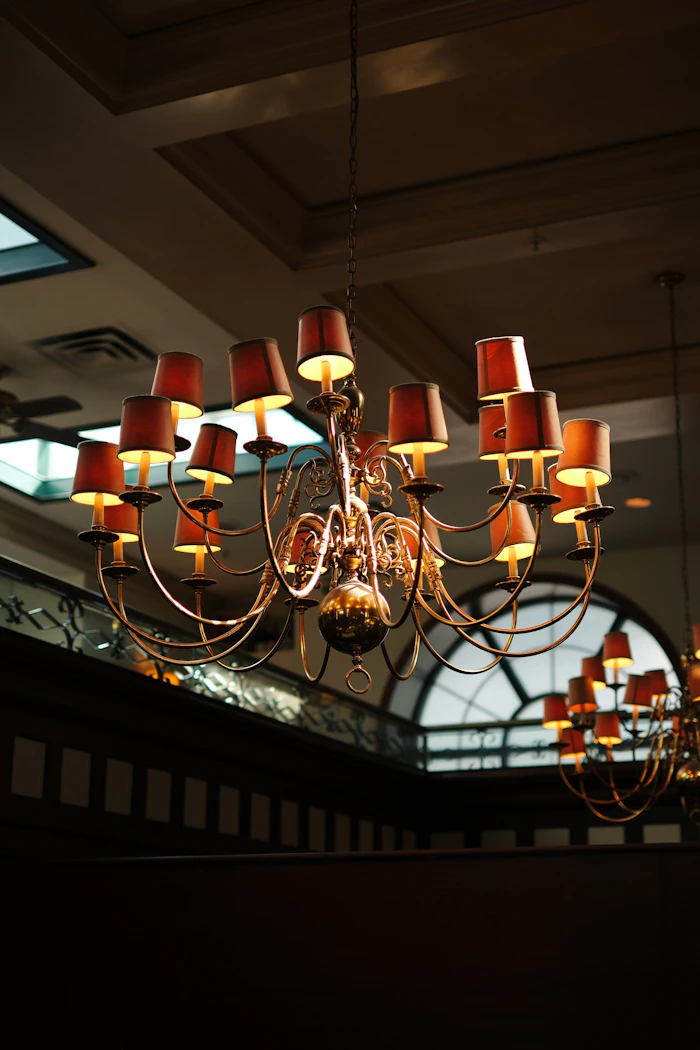 A brass chandelier with red shades over the dining room