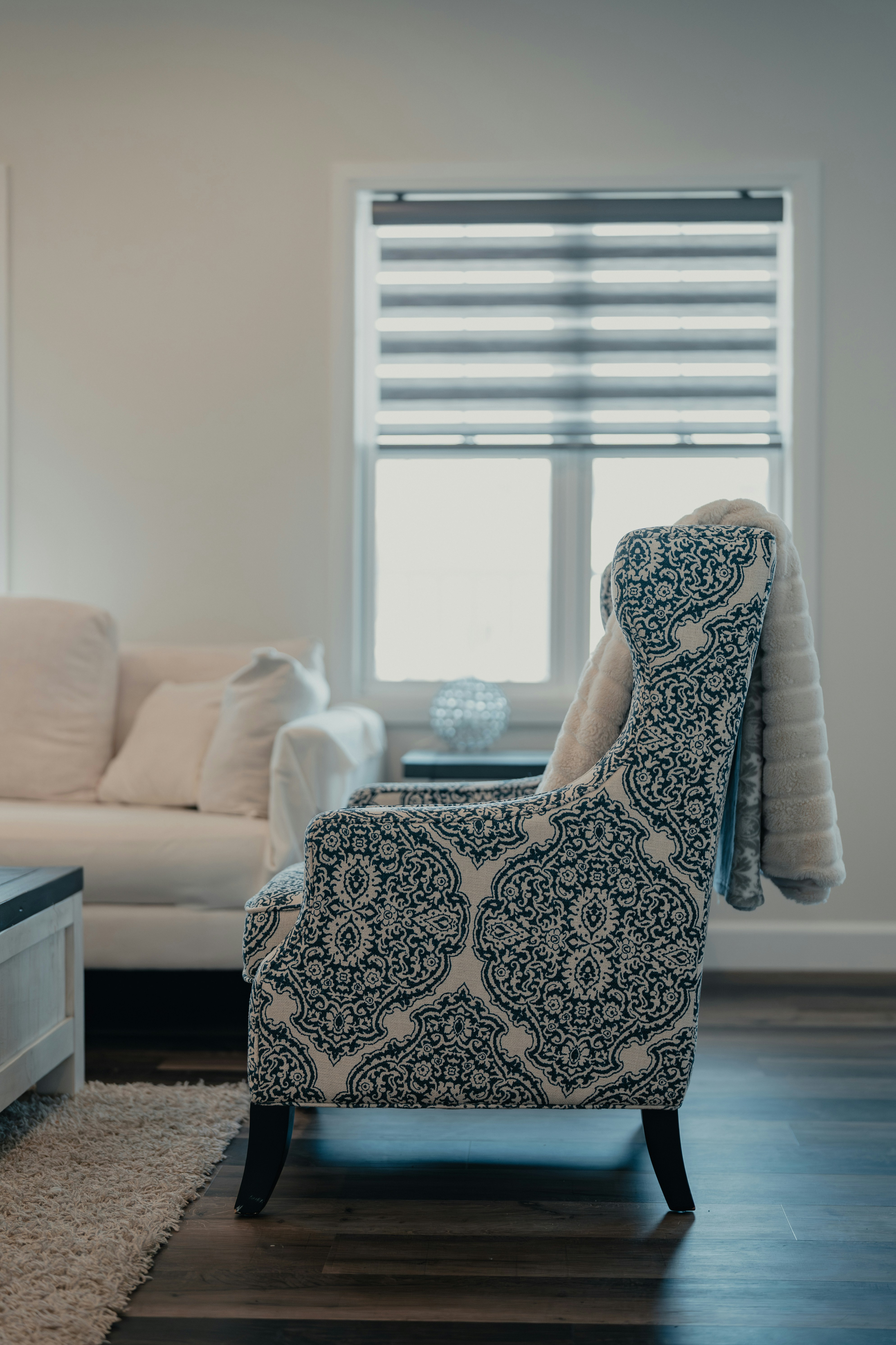 窓際の毛布付きの柄入りアームチェア