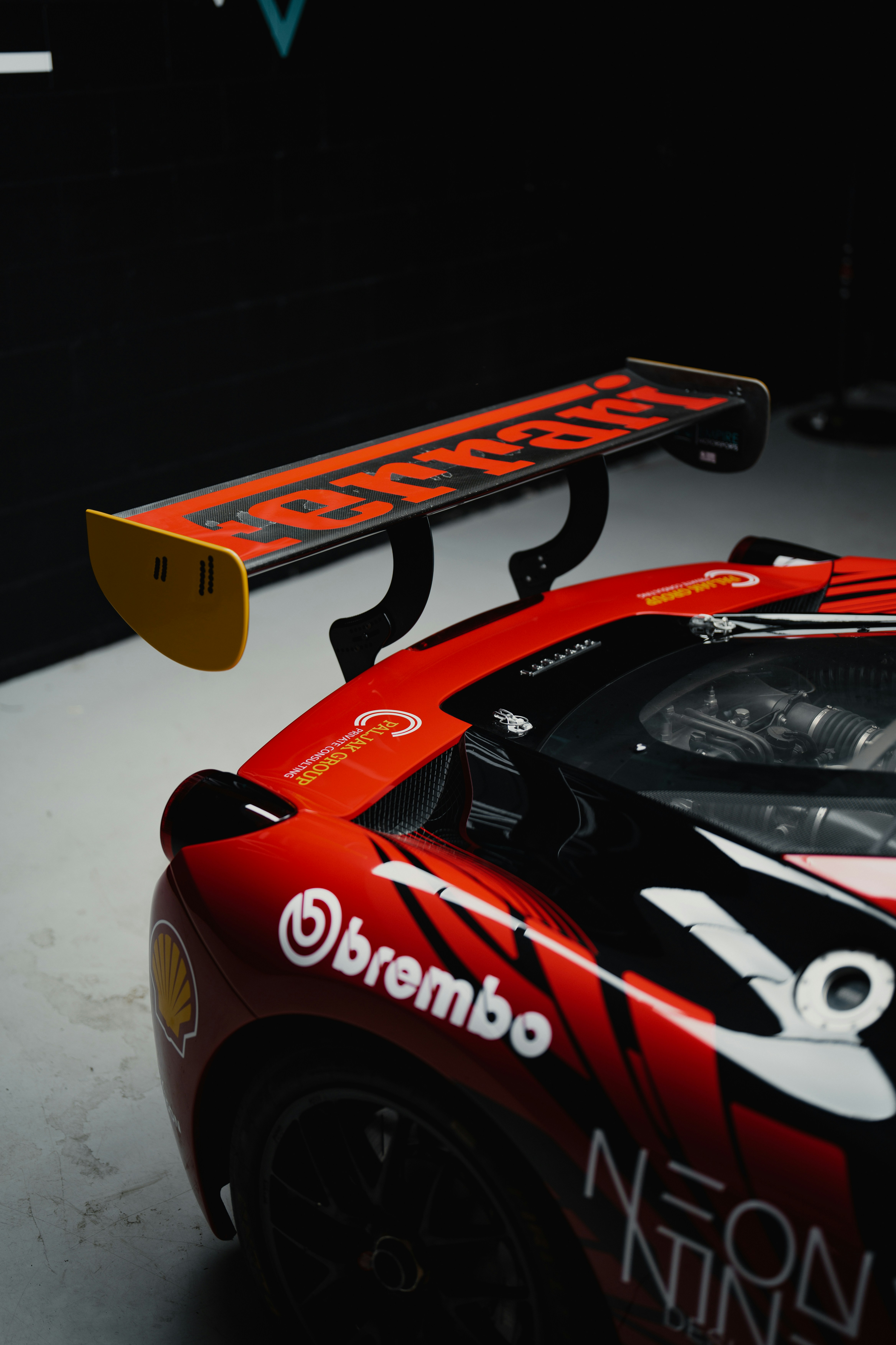 スポンサーのデカールとスポイラーの詳細が貼られた赤いレーシングカー