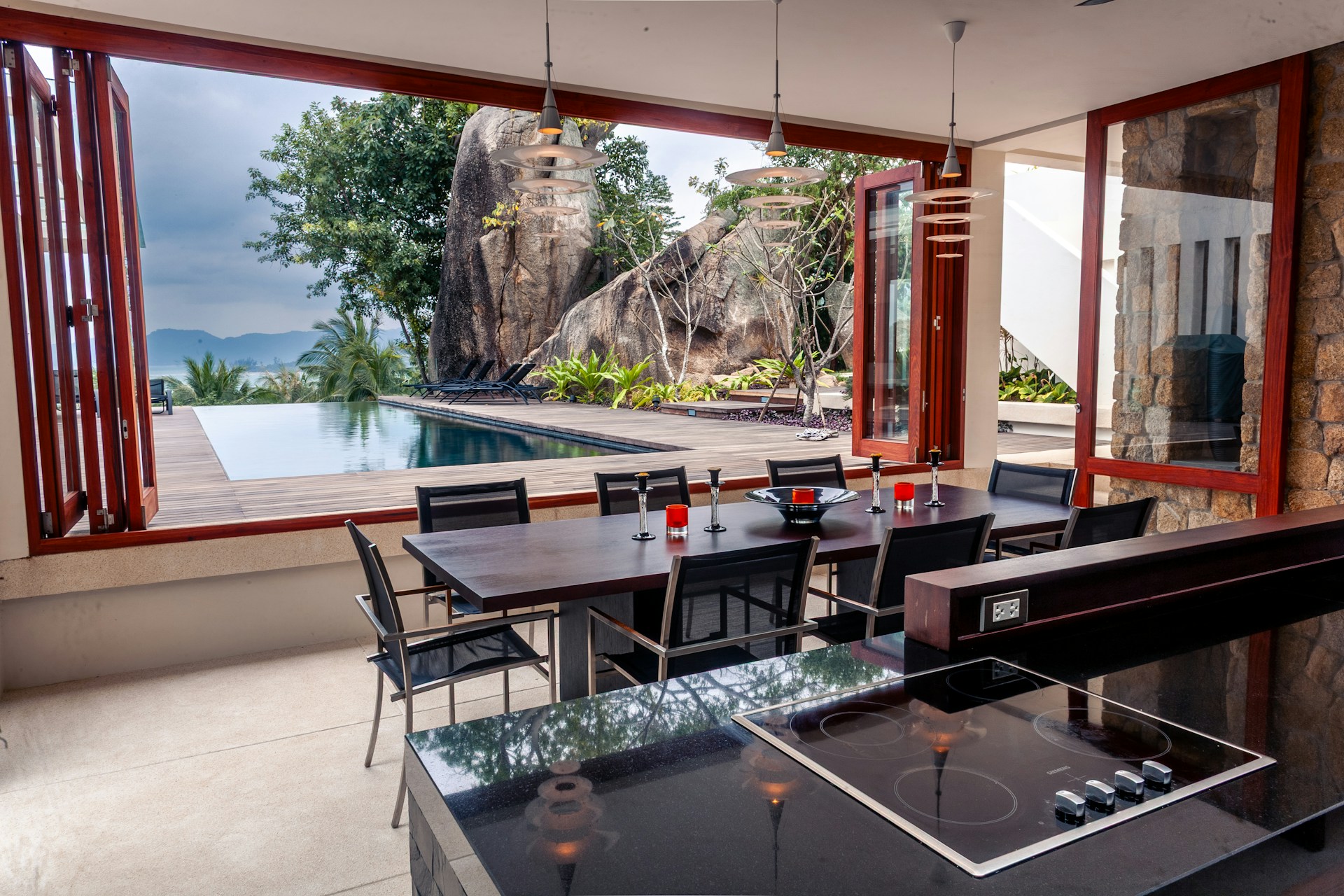 Modern dining area with pool and rocky landscape view
