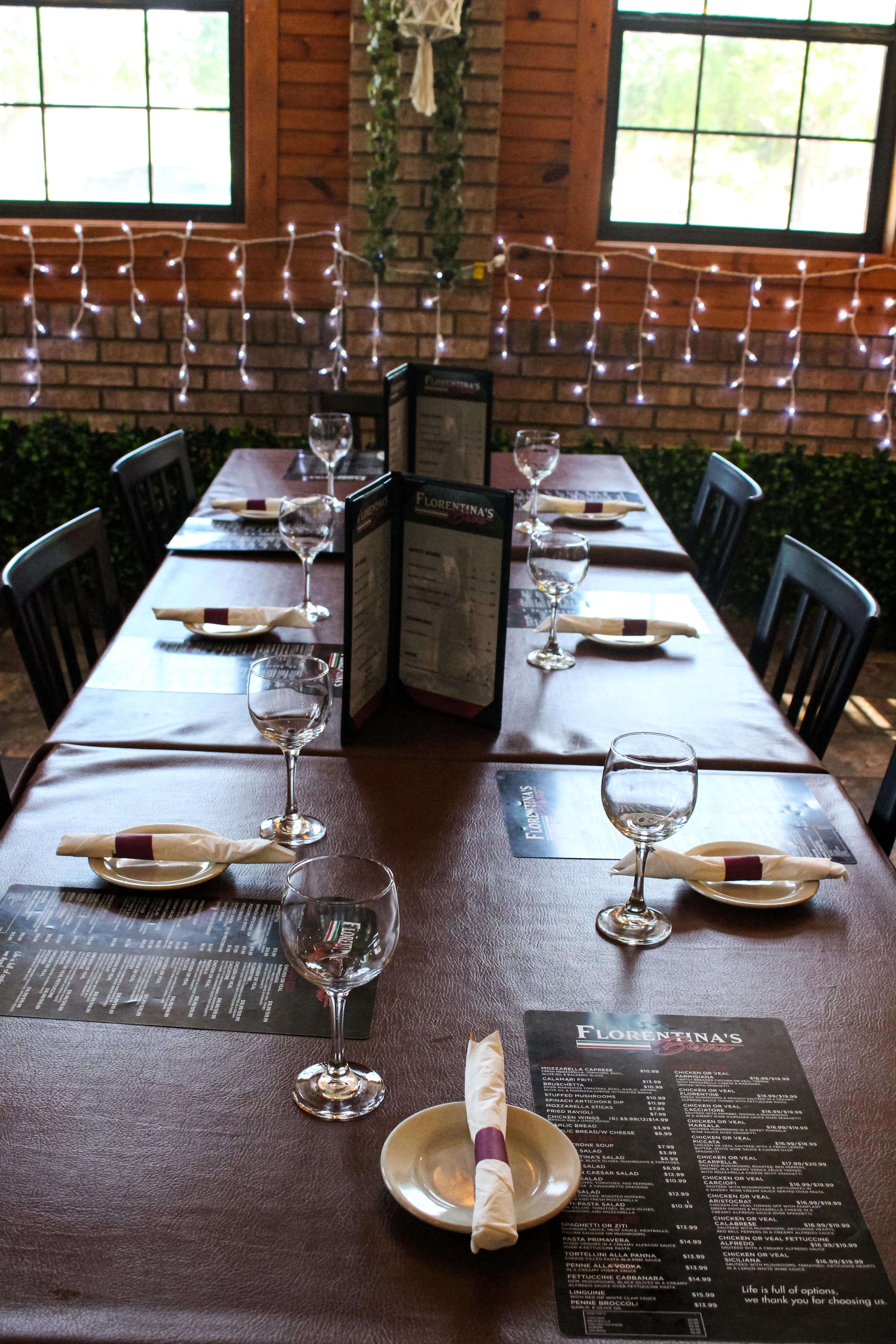 A restaurant table set with napkins, glasses and menus