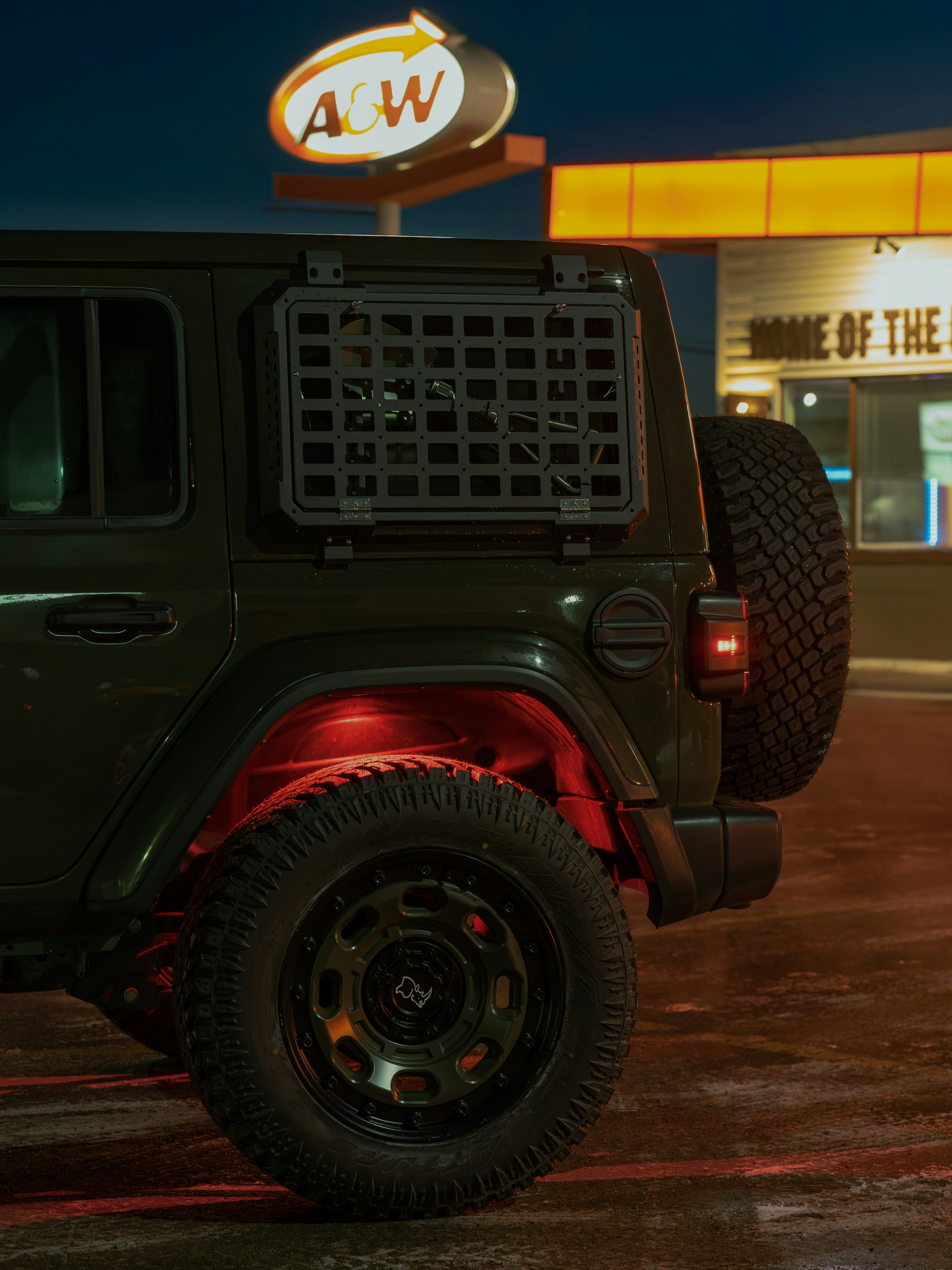 Green jeep parked outside a&w restaurant at night