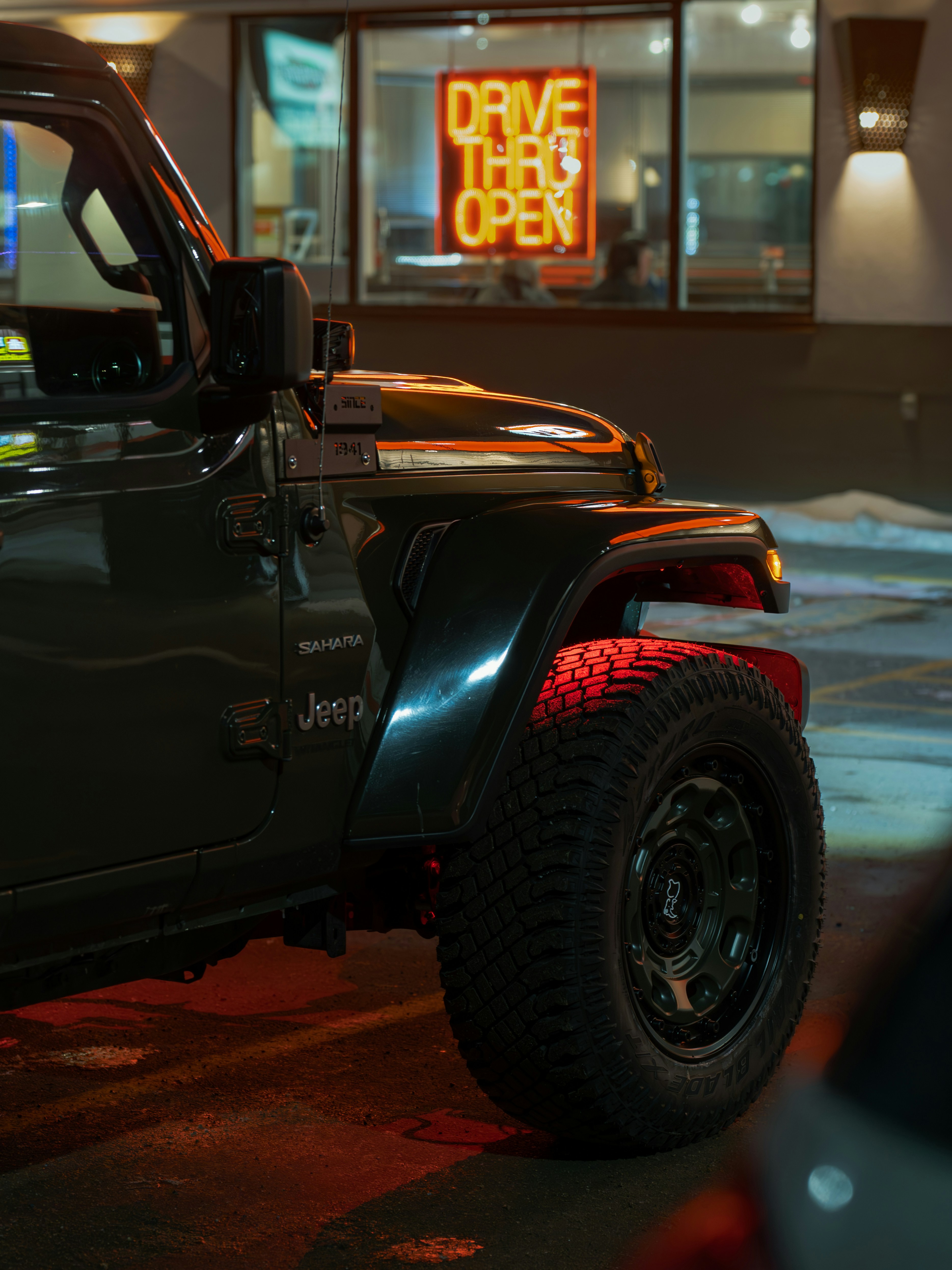 Jeep parked at a drive-thru at night.