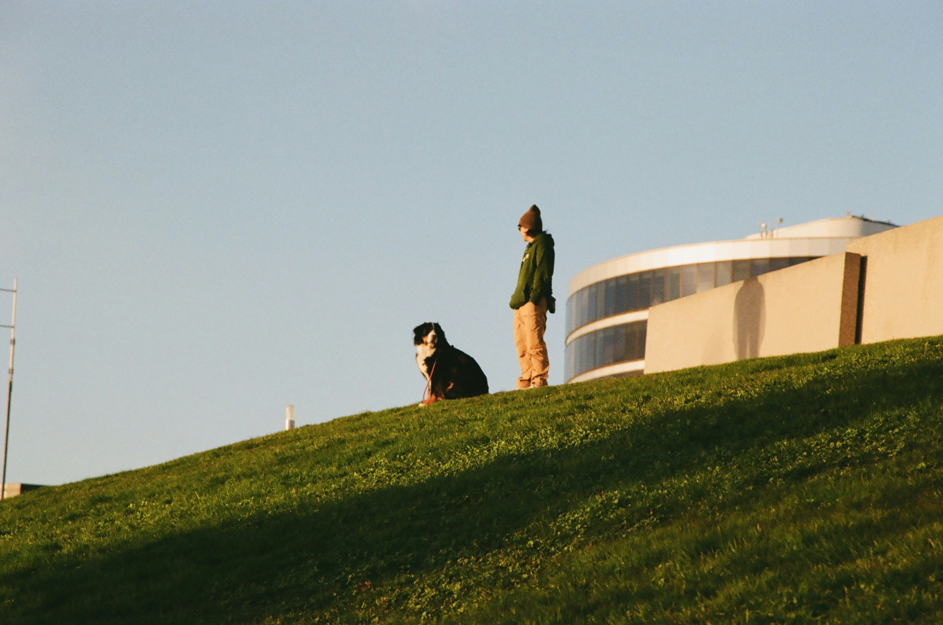Due persone su una collina erbosa vicino a un edificio
