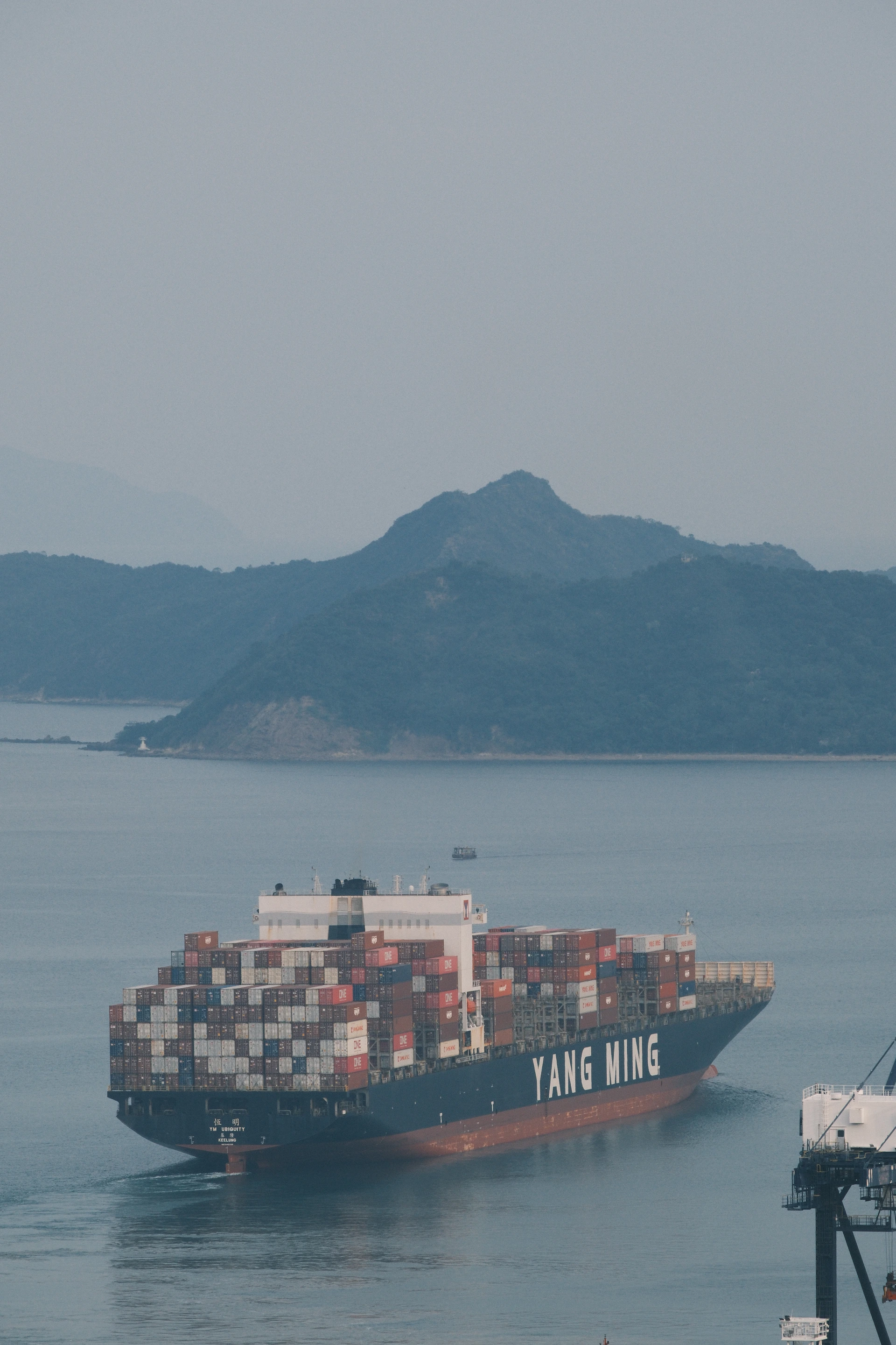 Large cargo ship ym efficiency sails on the water.