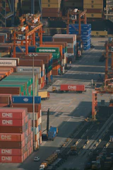 Shipping containers stacked high at a busy port.