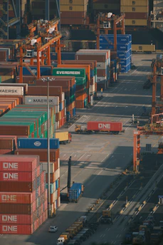 Shipping containers stacked high at a busy port.