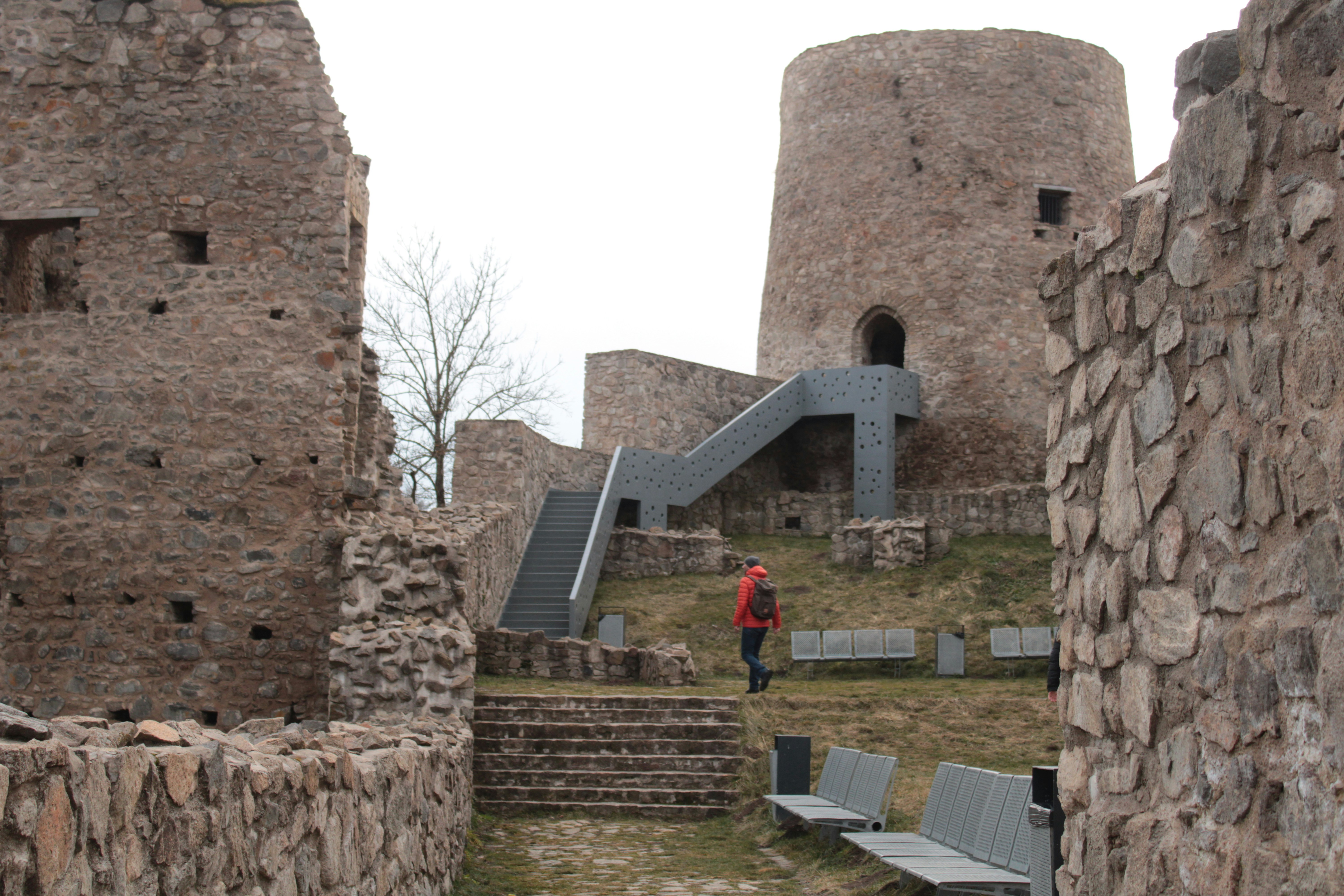 Ruínas de um castelo de pedra com torre redonda.
