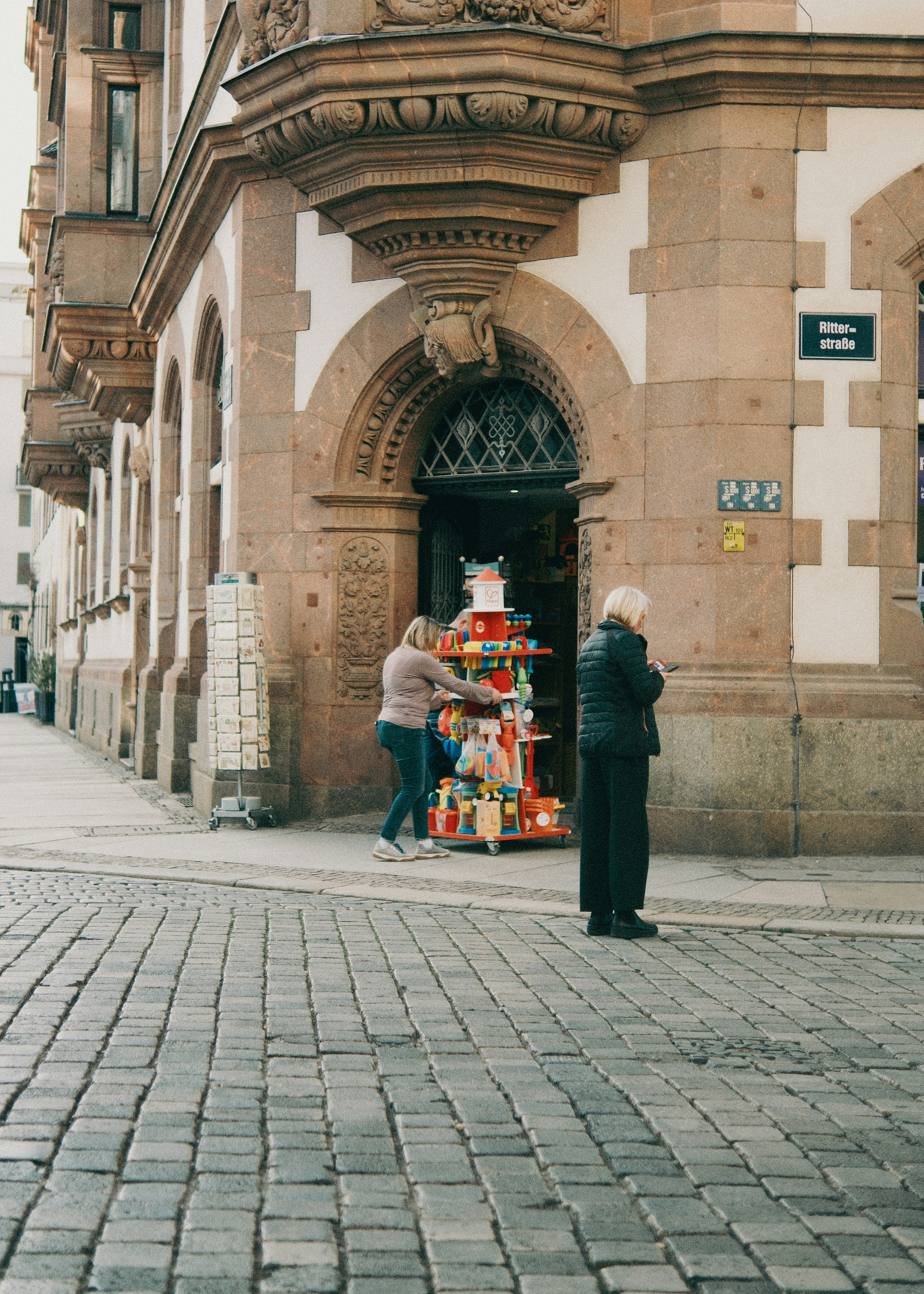 Frau, die auf den Einkaufswagen eines bunten Straßenverkäufers schaut.
