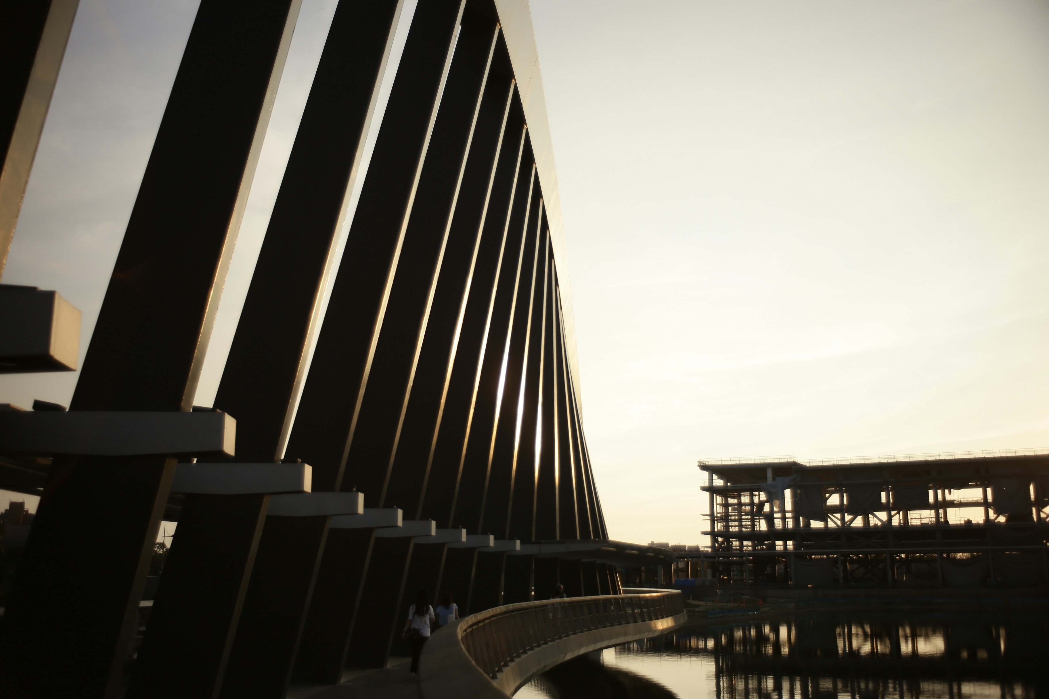 Estrutura arquitetônica moderna refletindo na água ao pôr do sol