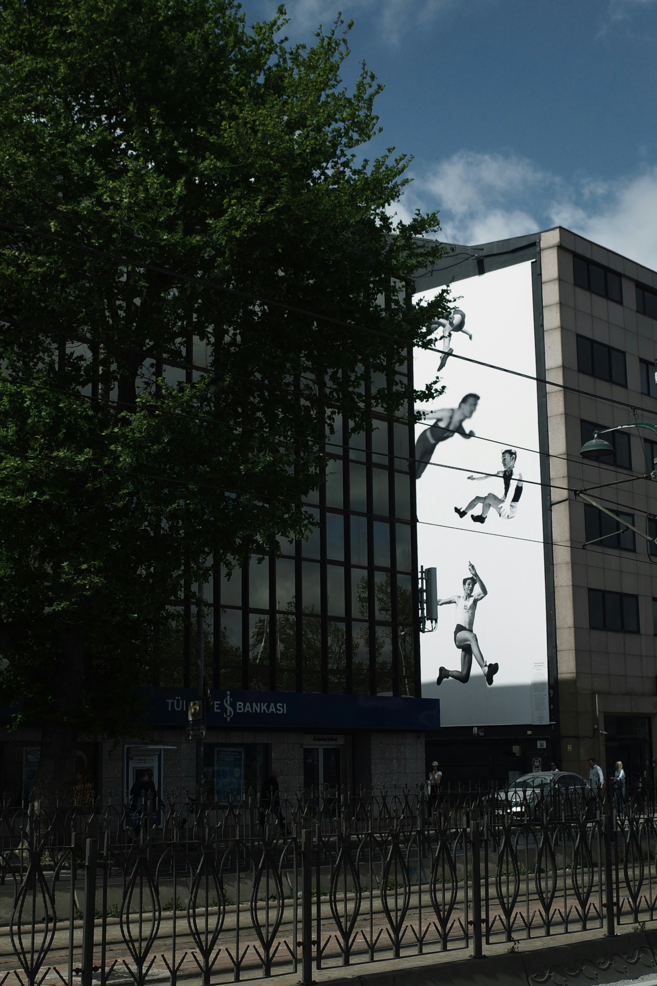 Graffiti art on a building facade with people jumping