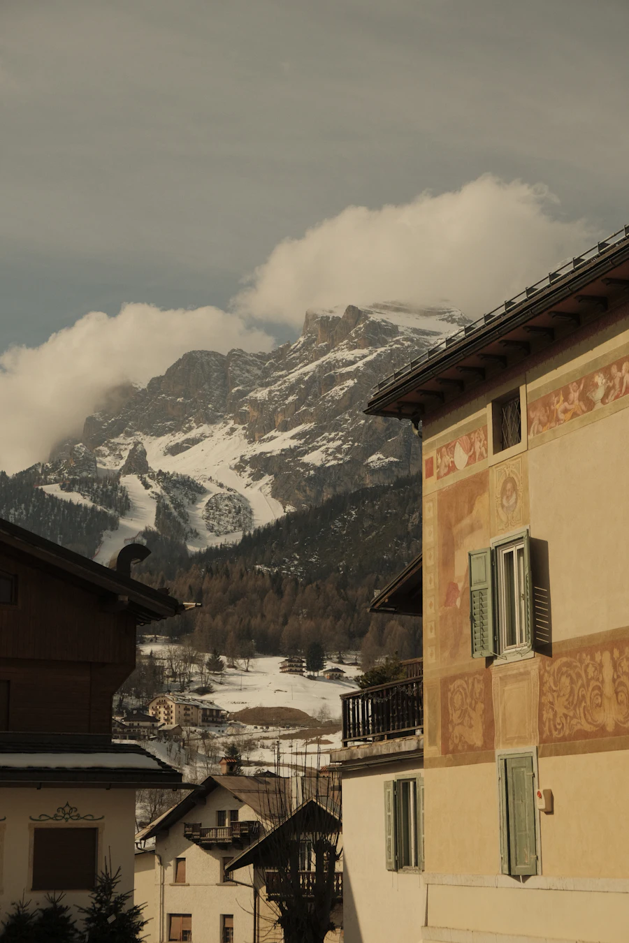Snowy Dolomites peaks rising above Cortina d'Ampezzo village rooftops