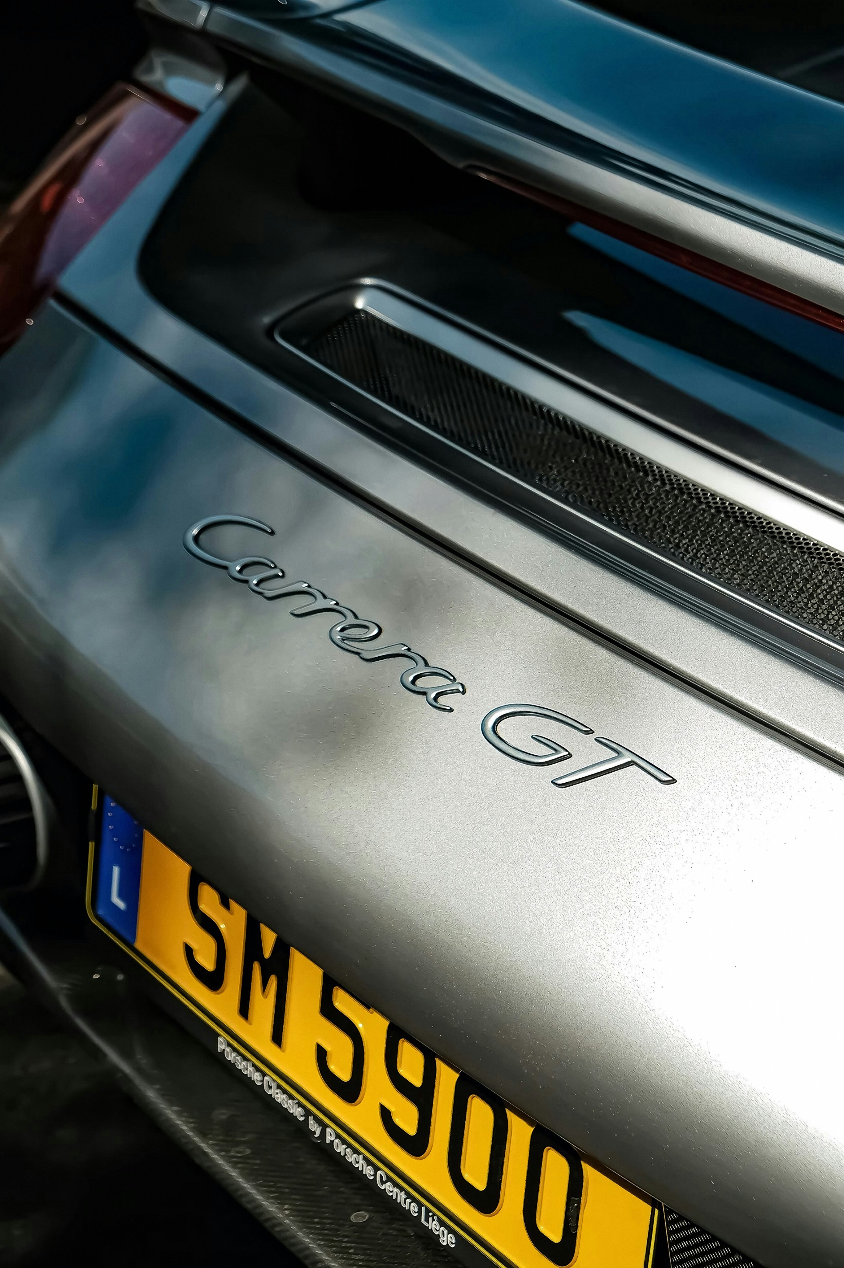 Silver porsche carrera gt with yellow license plate