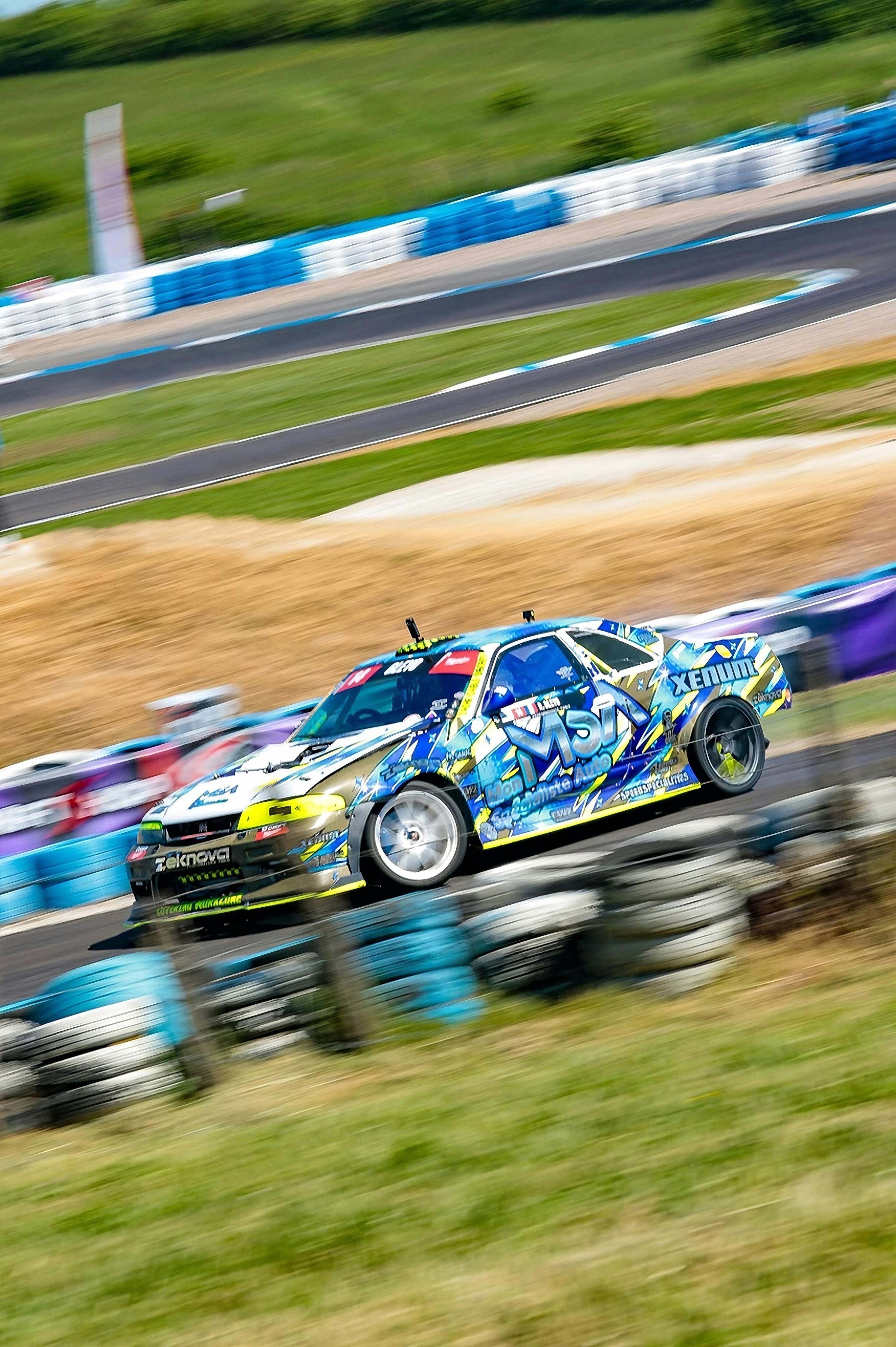 A race car drifts around a corner on a track