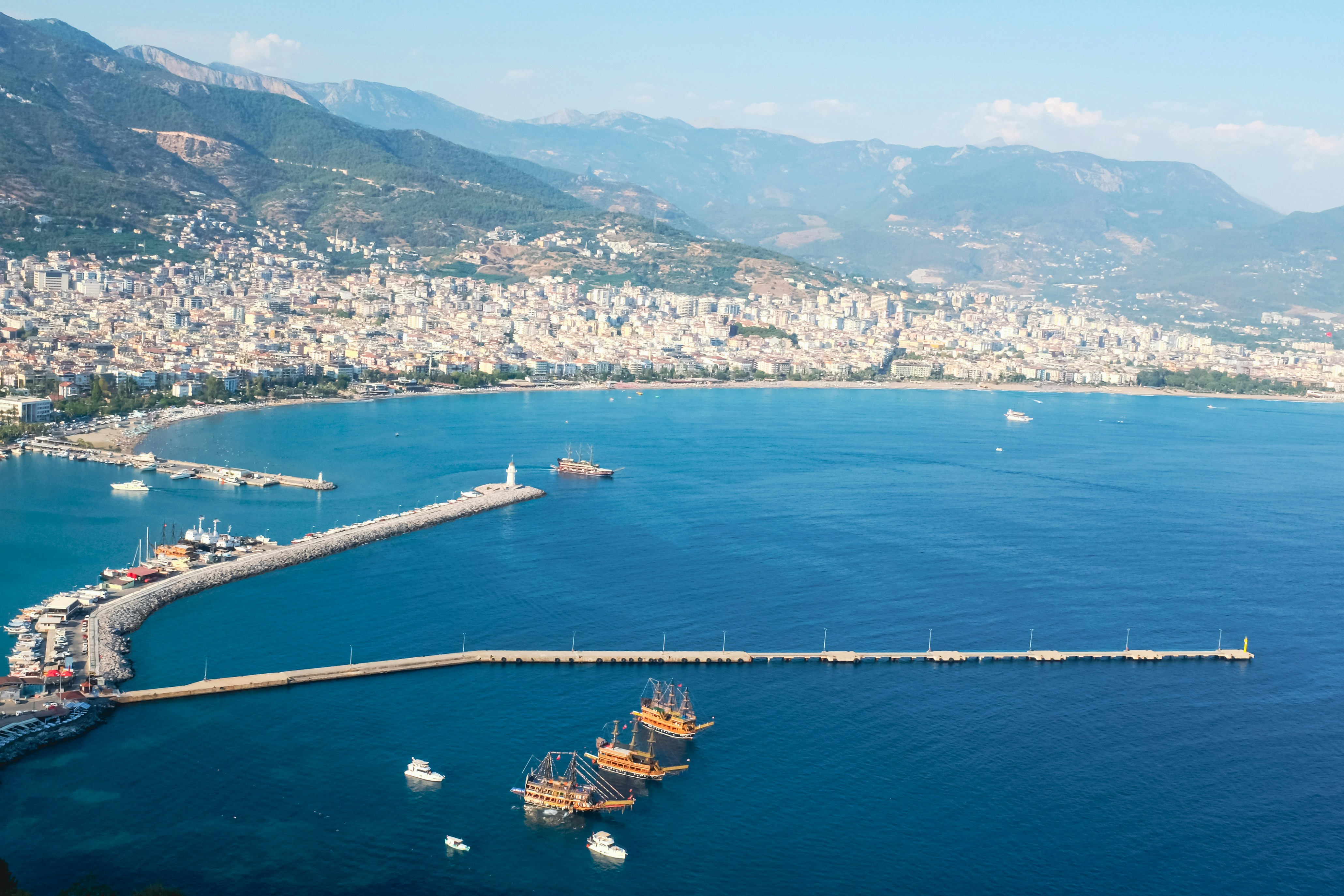 Coastal city with harbor and mountains in background