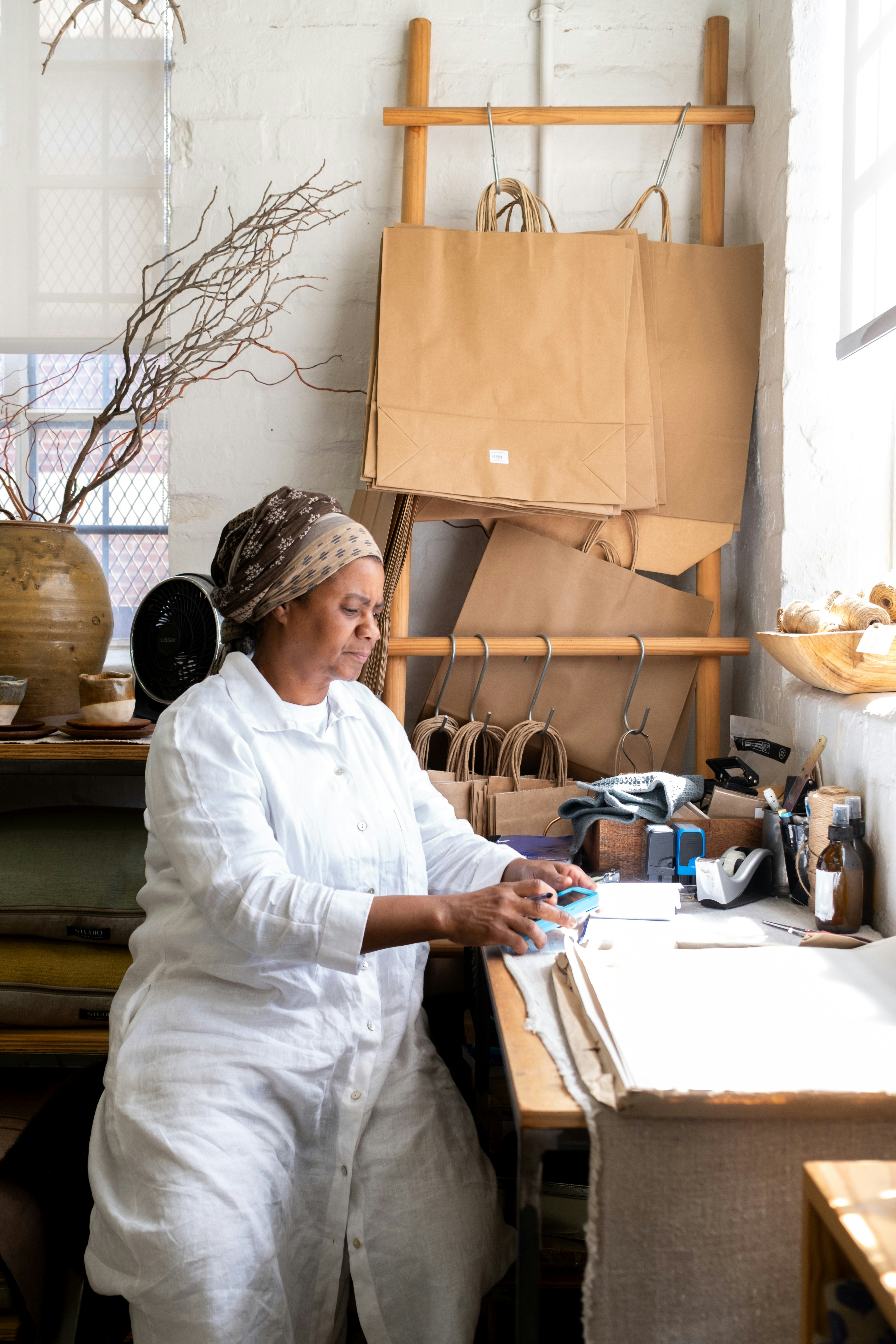 Woman working at a desk with craft supplies.