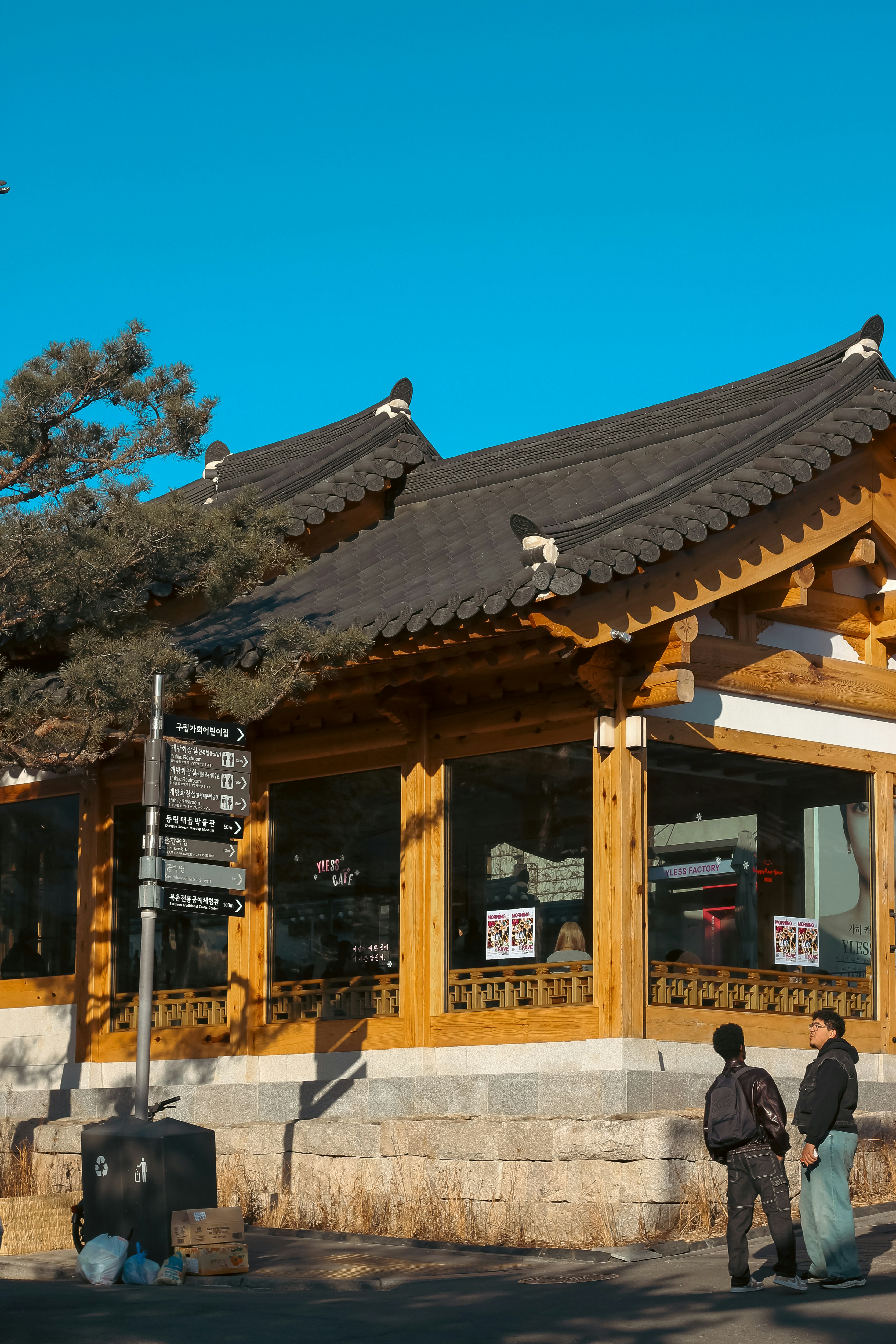 Two people stand outside a traditional korean building.