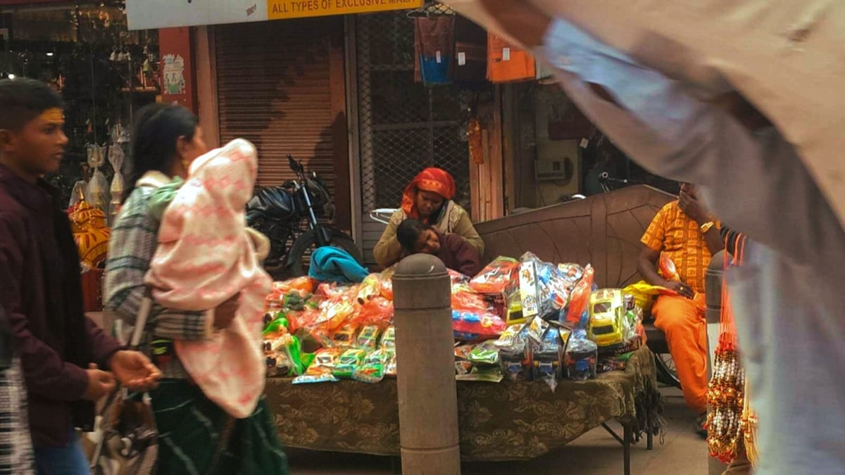 Street food vendor serving customers in a Varanasi market lane