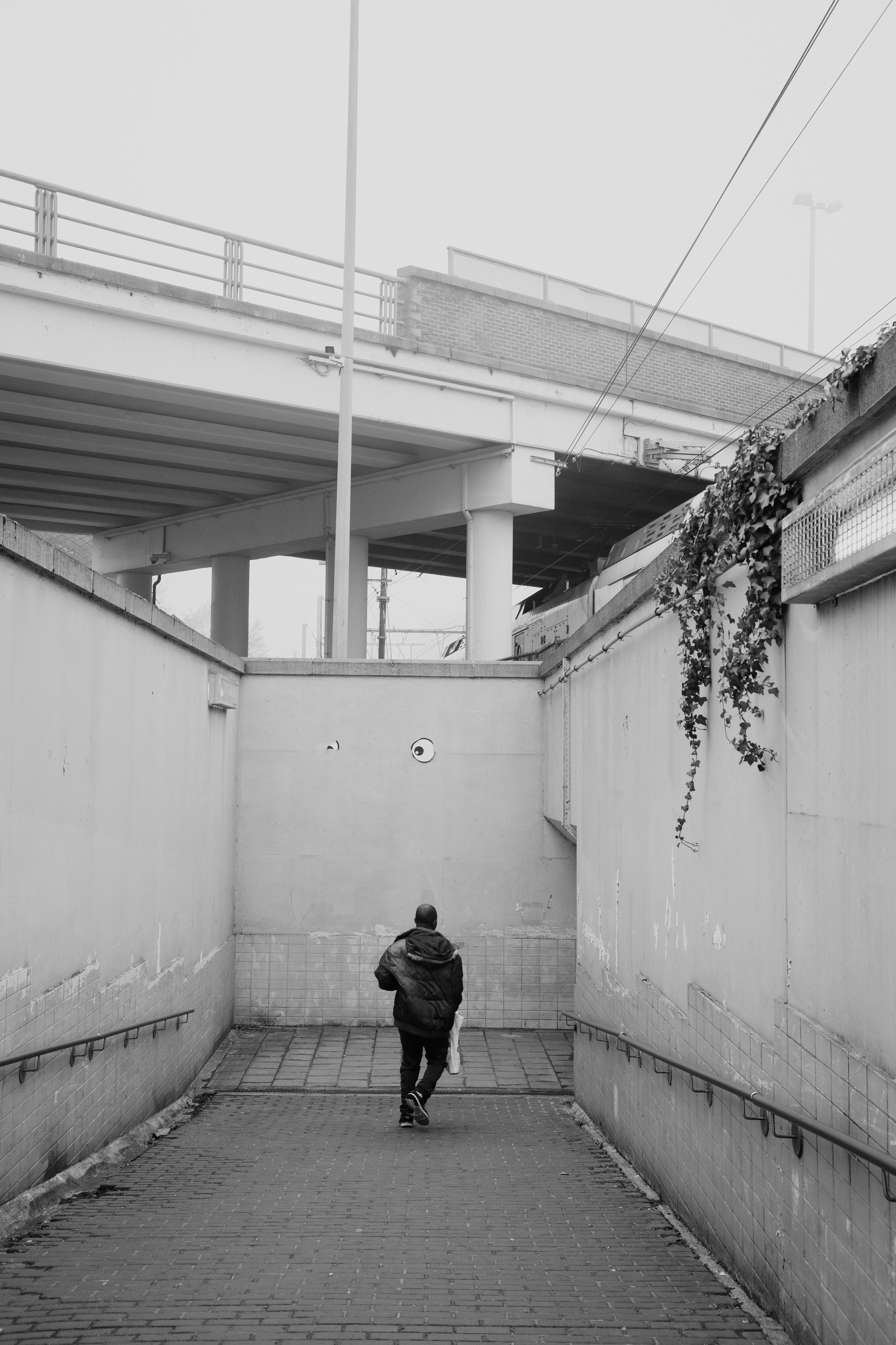 コンクリートの地下道を歩いている人が架橋を歩いている