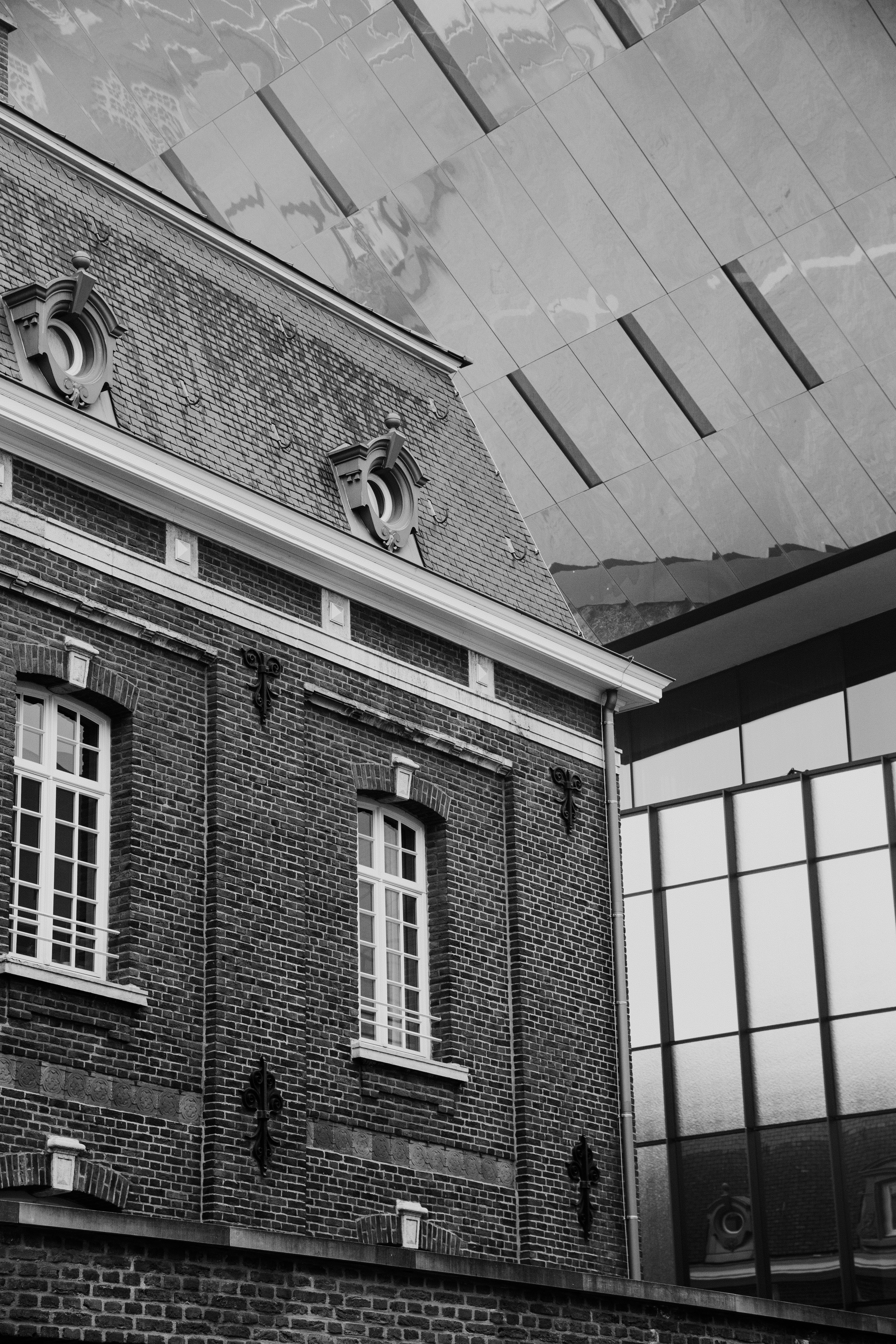 古いレンガ造りの建物で、現代的なガラスファサード