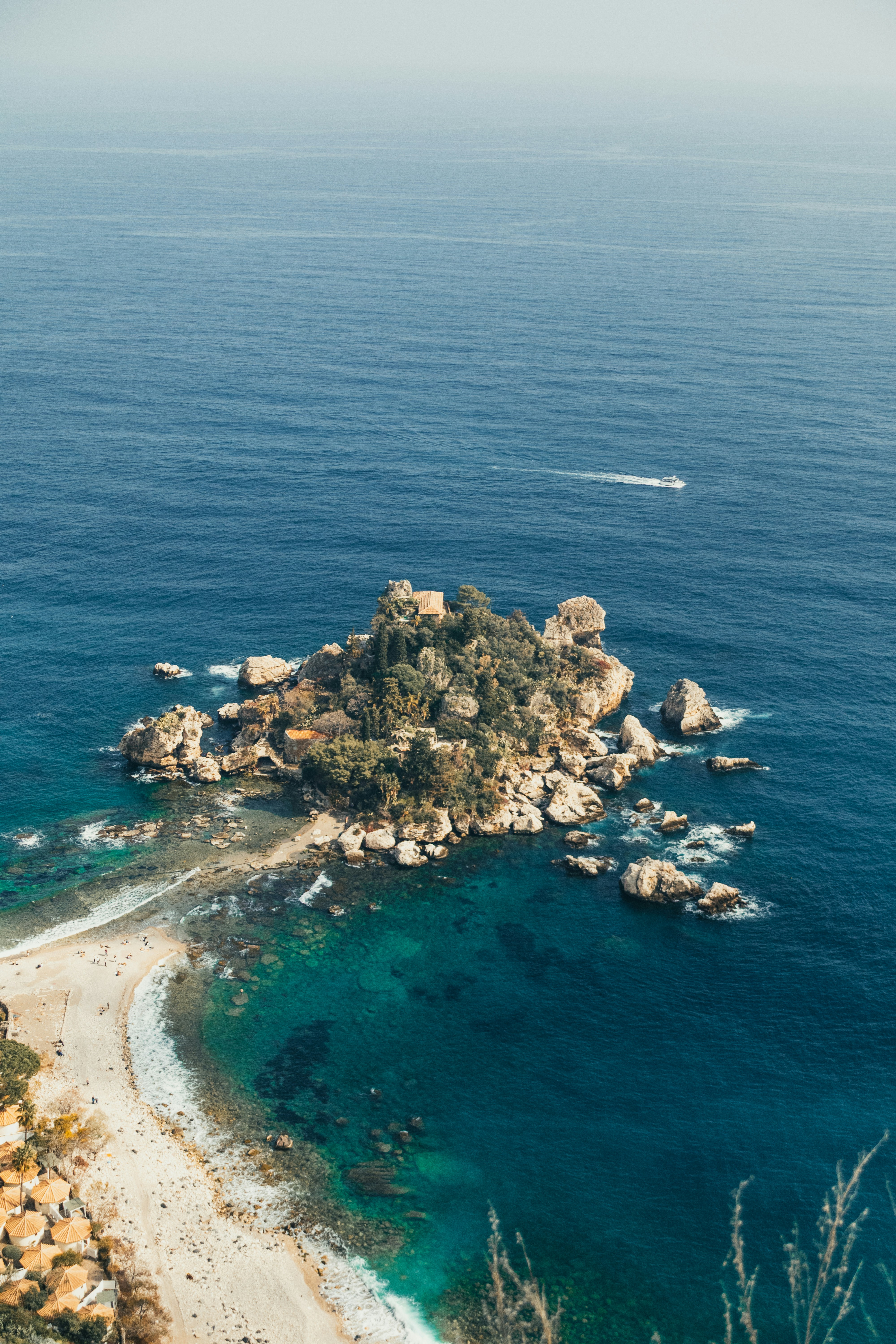 Rocky island with trees surrounded by blue ocean water photo – Free ...
