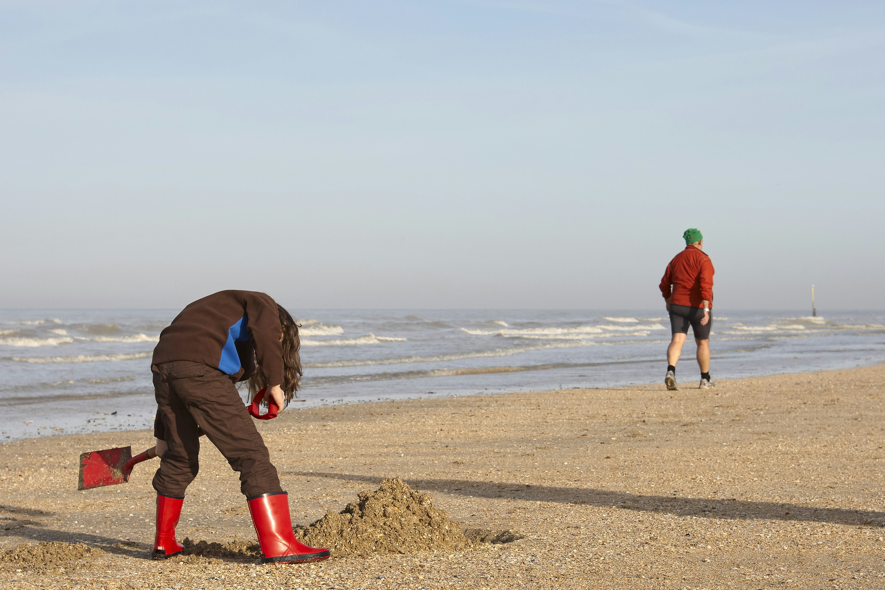 Two people on a sandy beach near the ocean