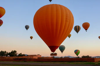 Several hot air balloons ascend into the clear sky