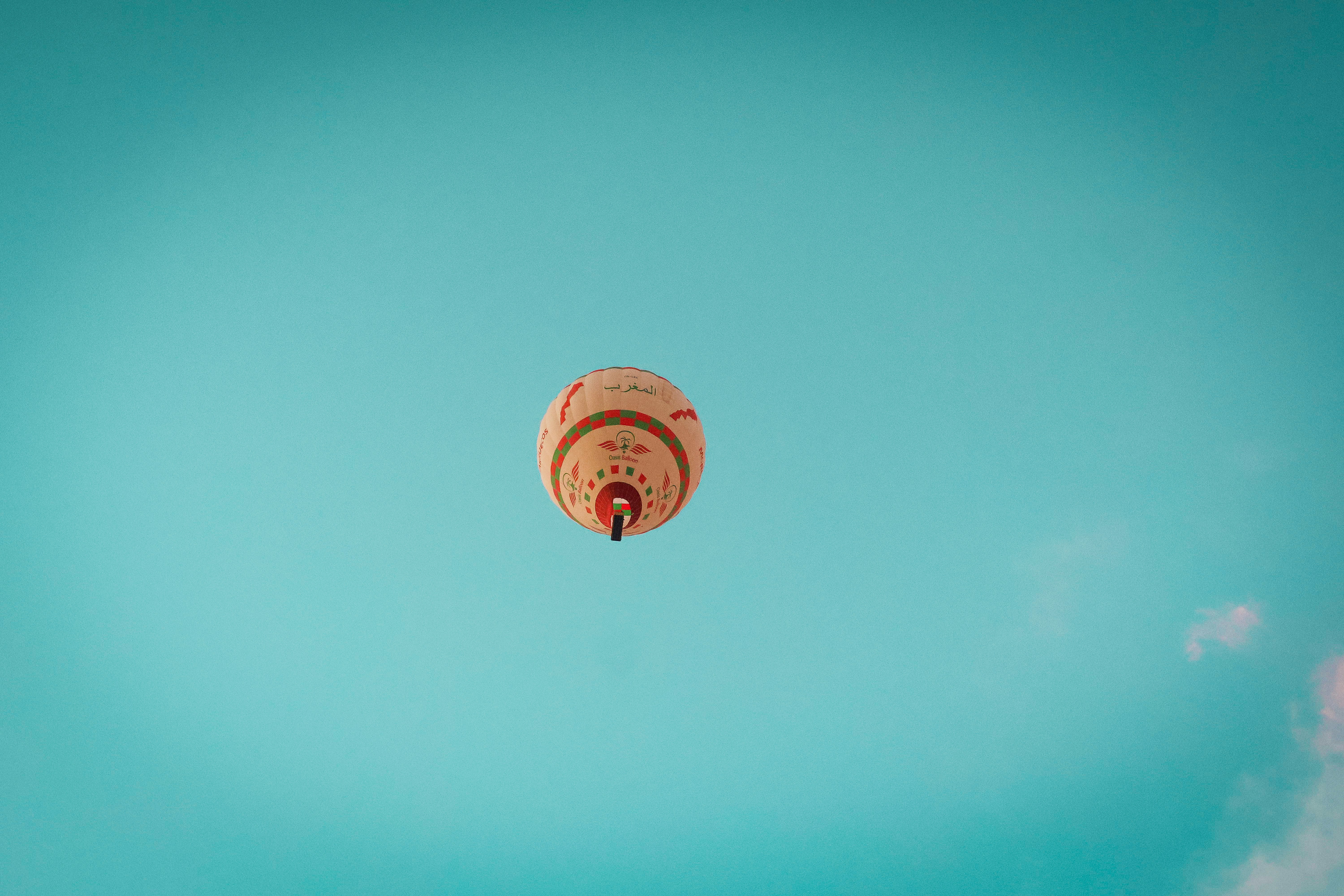 Un globo aerostático asciende hacia un cielo azul despejado.