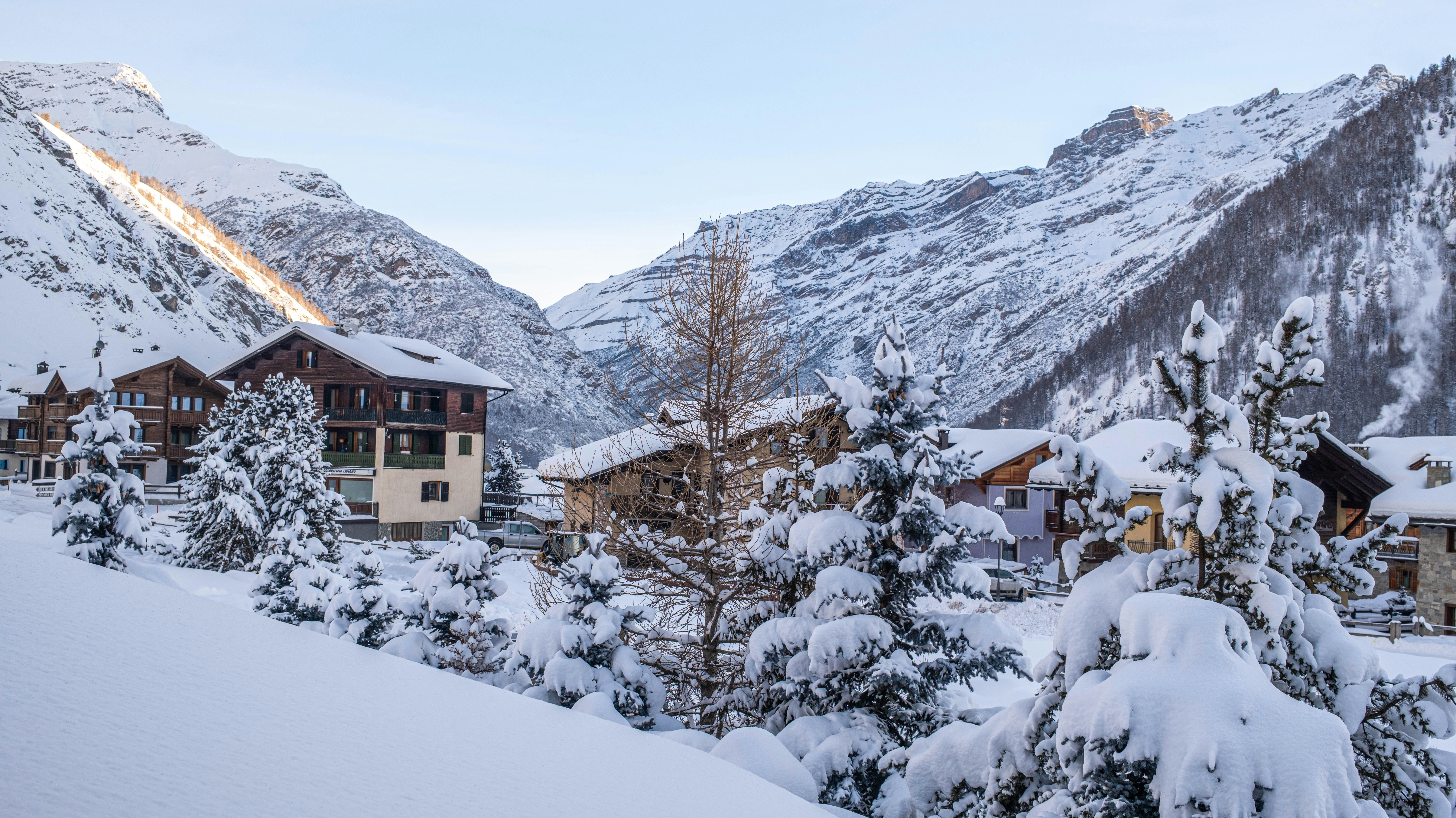 Snow-covered village nestled in a majestic mountain range.