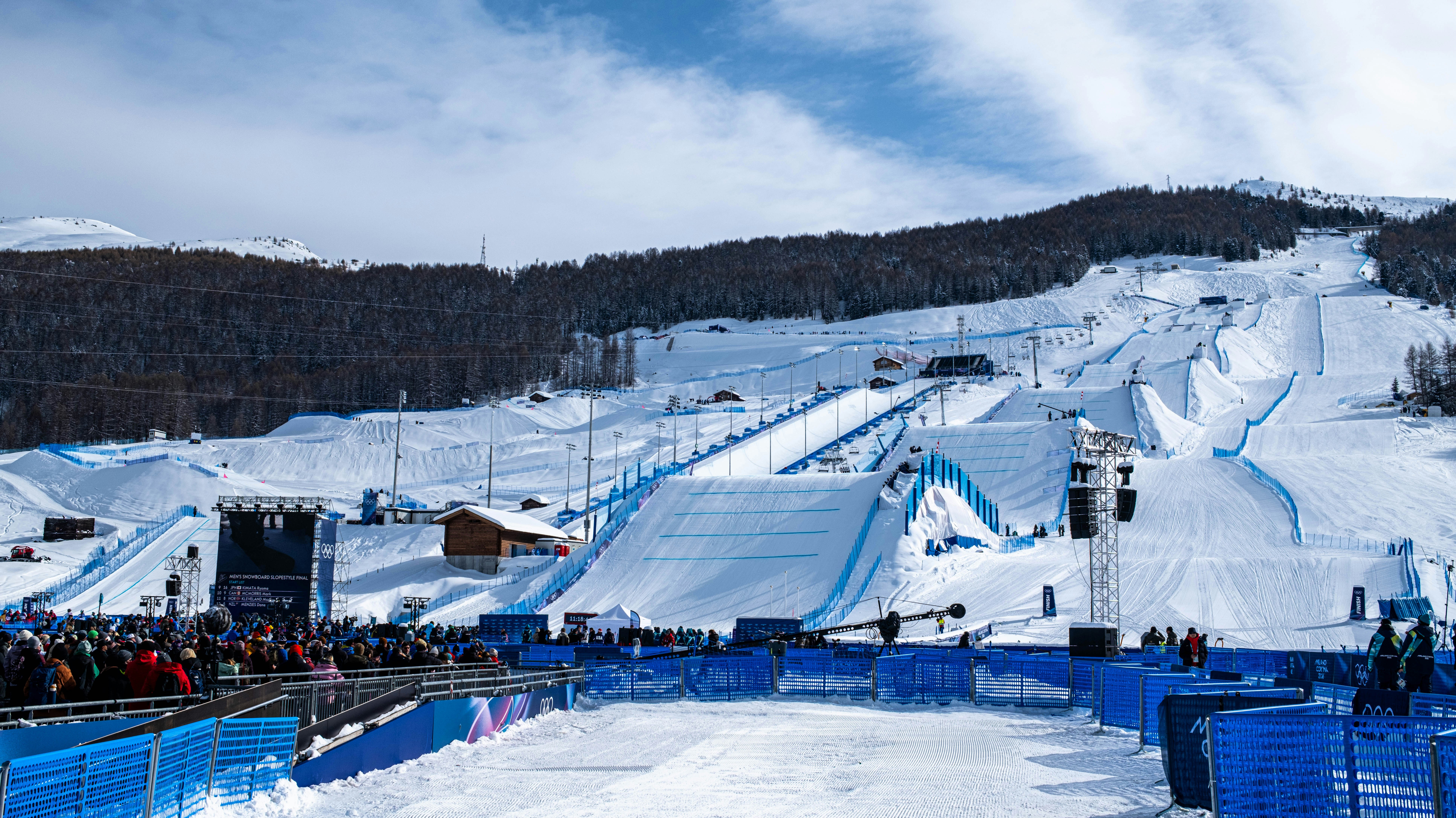 Snowy ski resort with large ramps and spectators