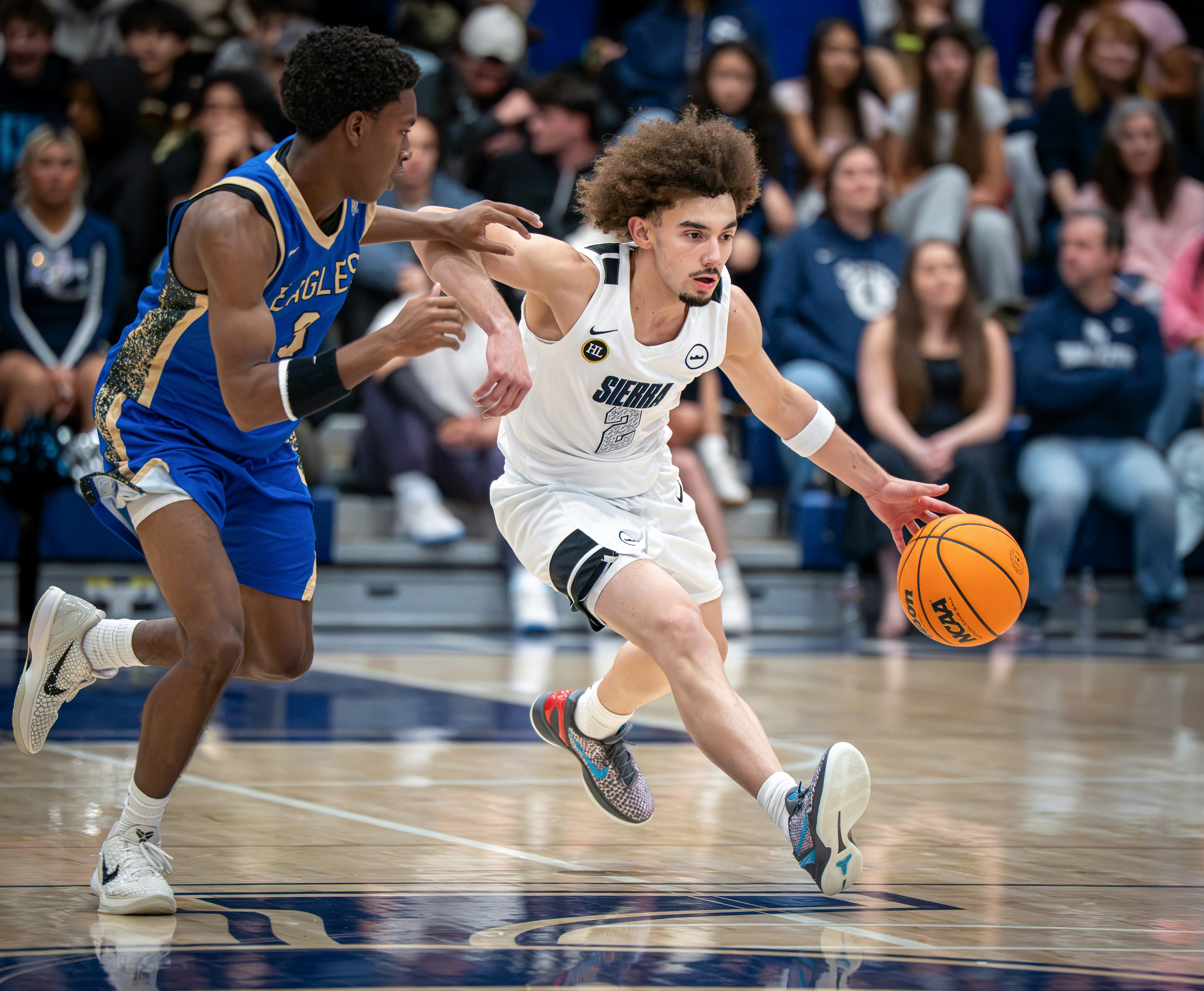 Basketball player dribbling past defender during a game