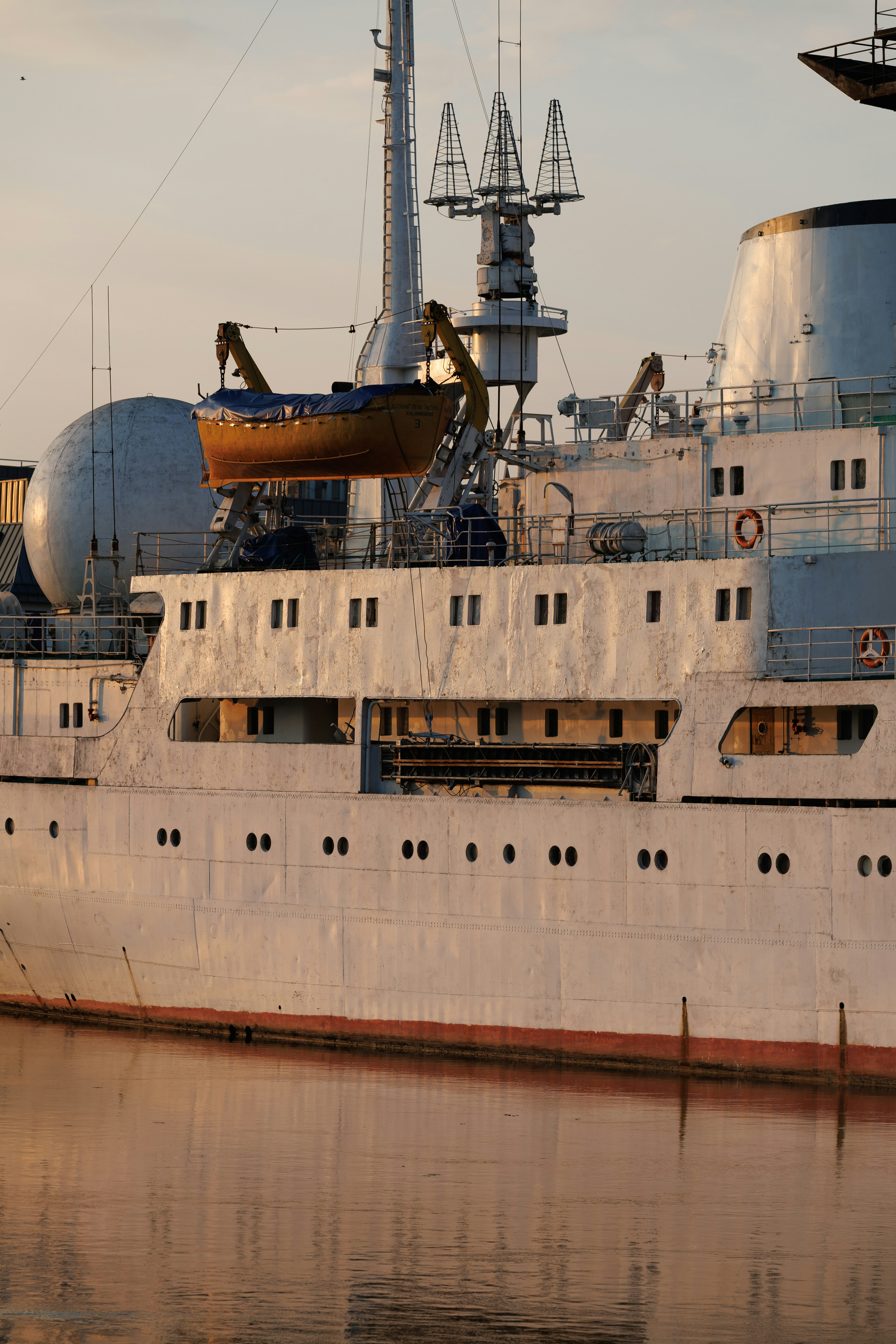 White ship with a lifeboat at sunset