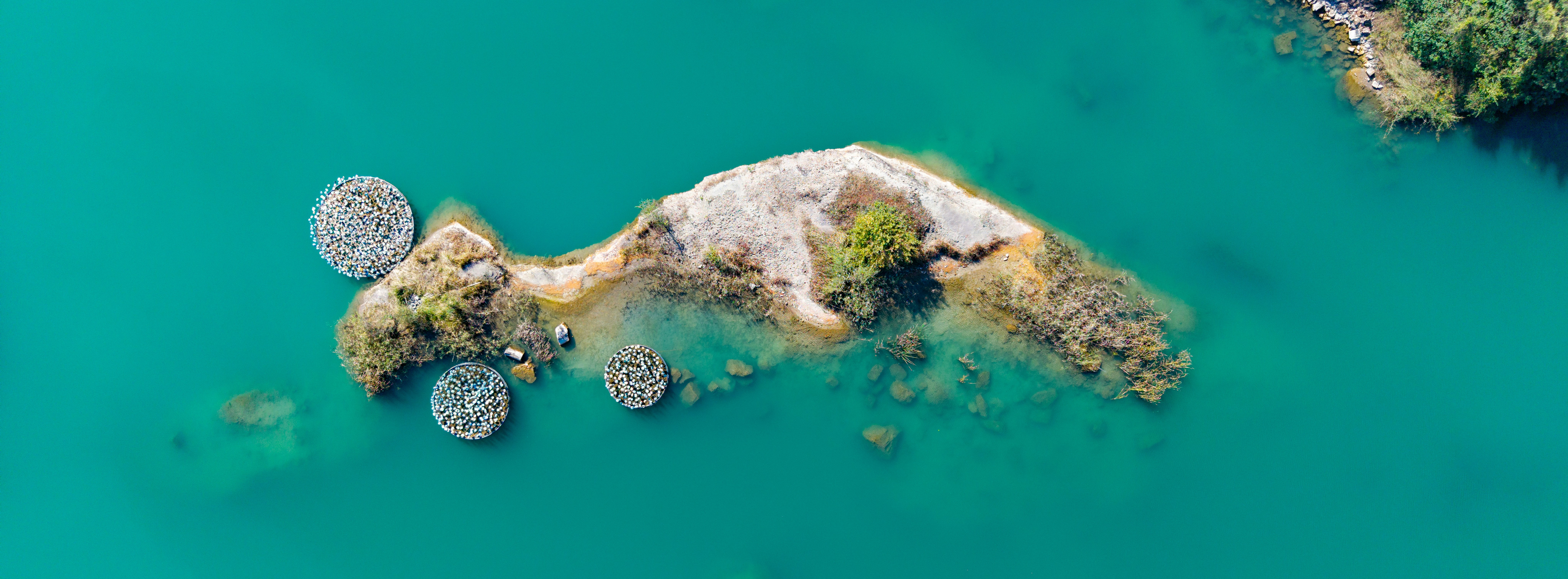 Aerial view of a fish-shaped island in turquoise water