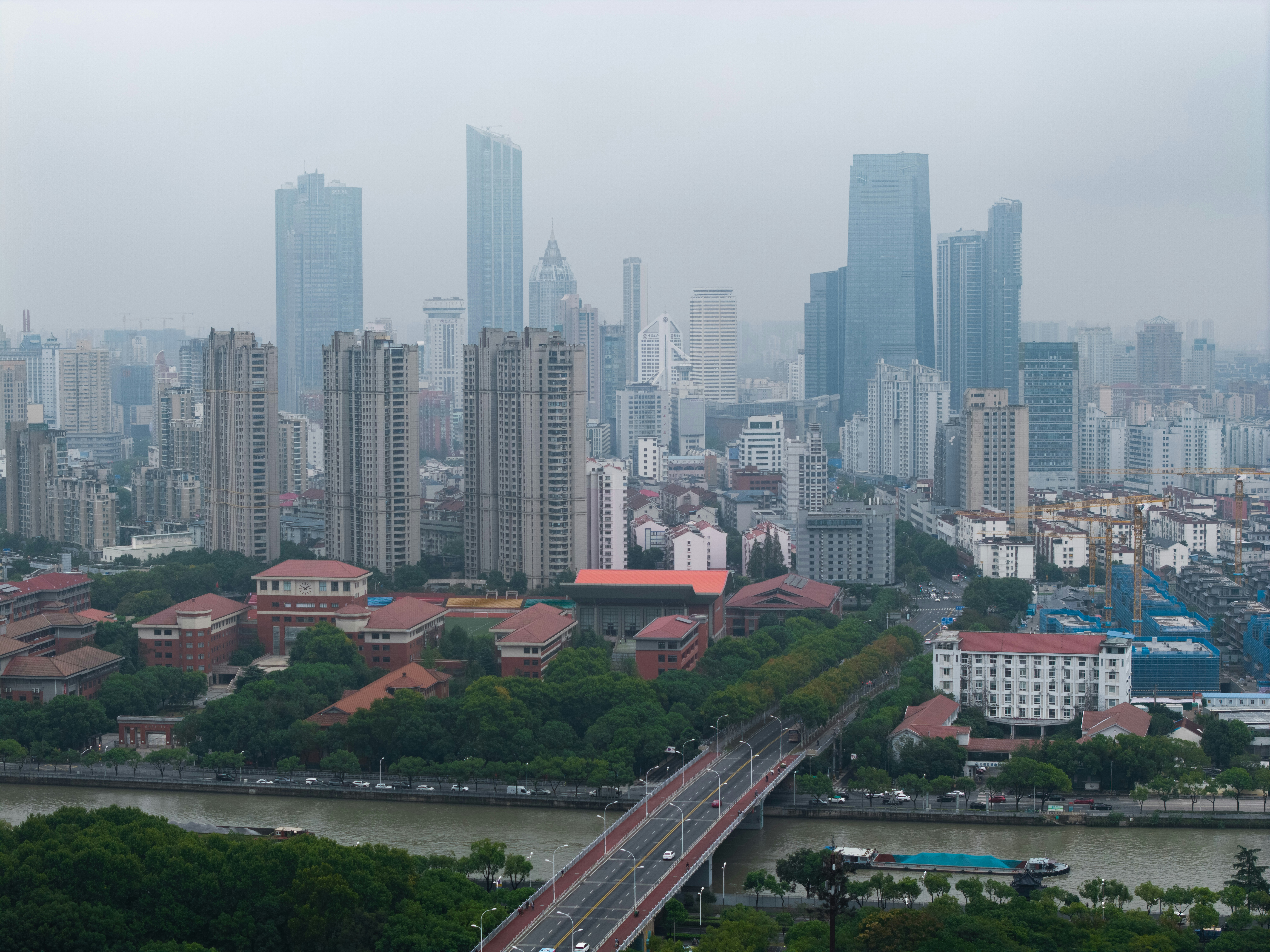 City skyline with tall buildings and a bridge.