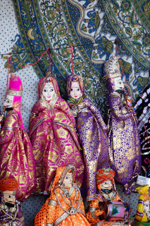 Colorful traditional indian puppets displayed on a patterned background